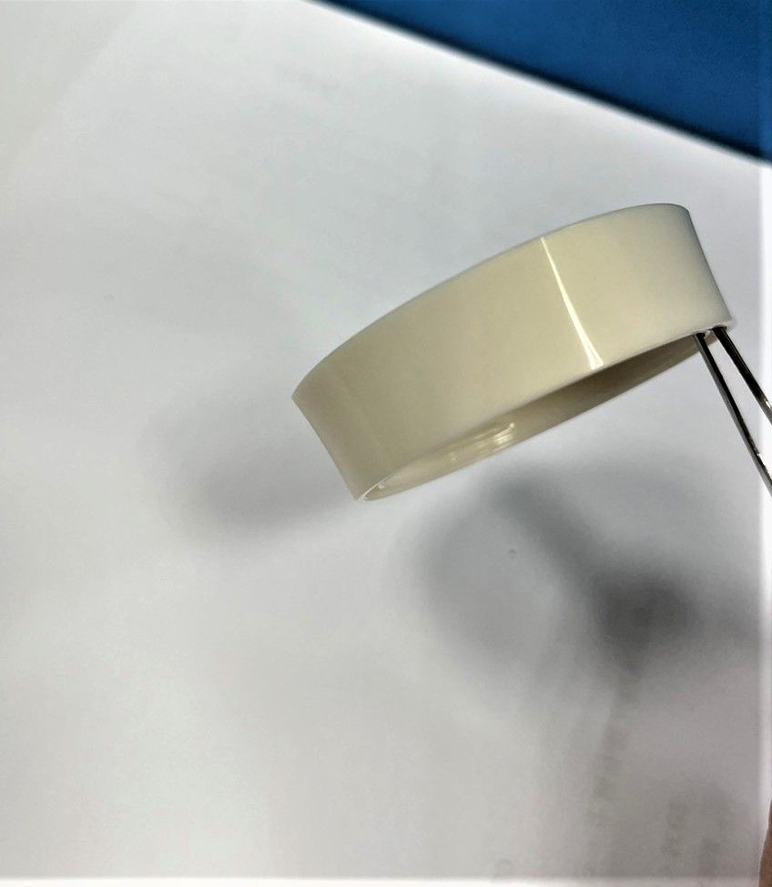 A piece of white tape is being held by a pair of tweezers