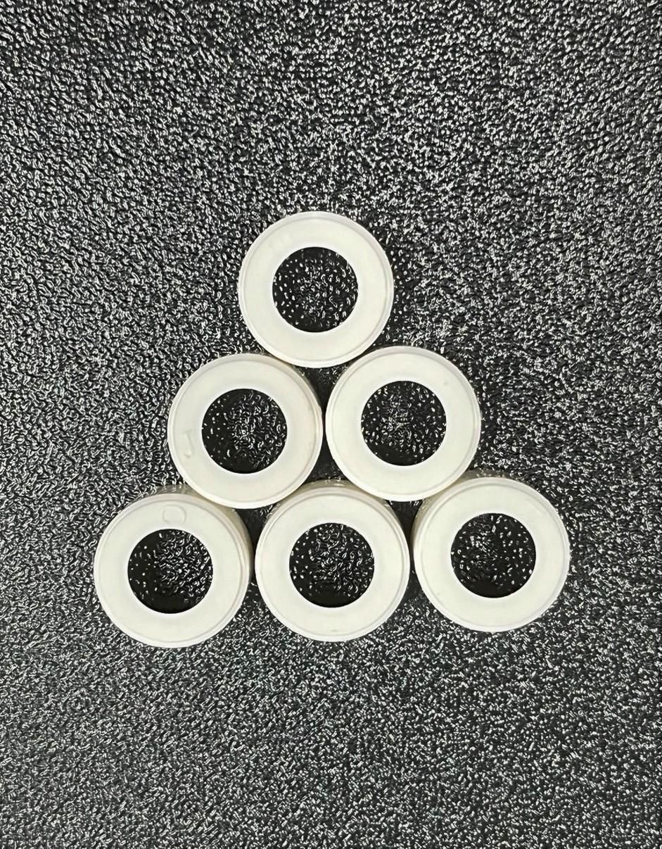A stack of white circles with holes in them on a gray surface.