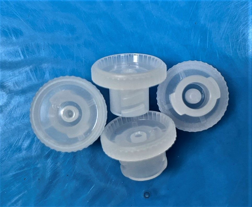 A group of clear plastic caps are sitting on a blue surface