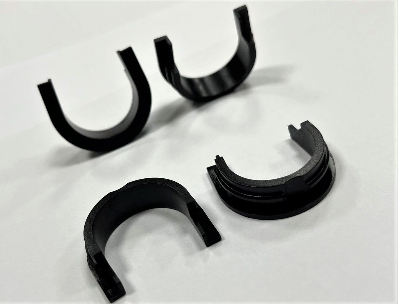 Three black plastic rings are sitting on a white surface.