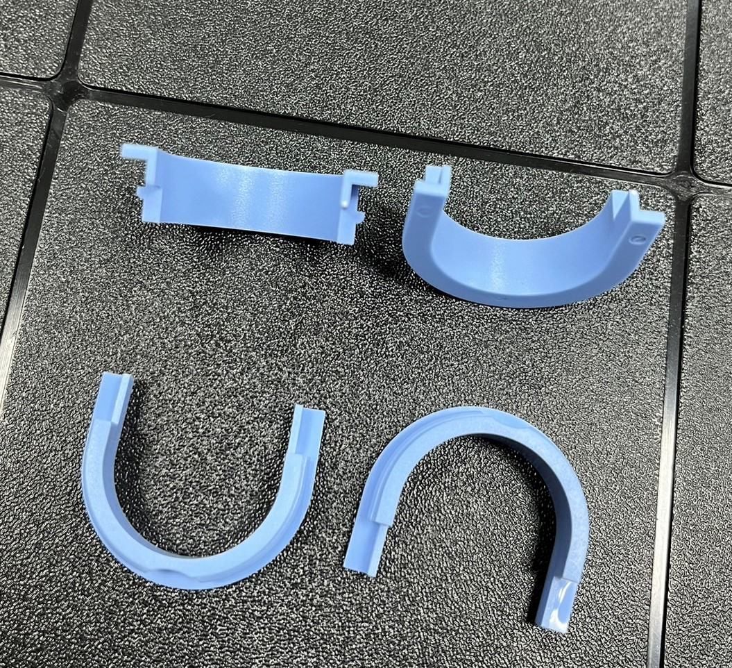 Two blue pieces of plastic are laying on a tiled floor.