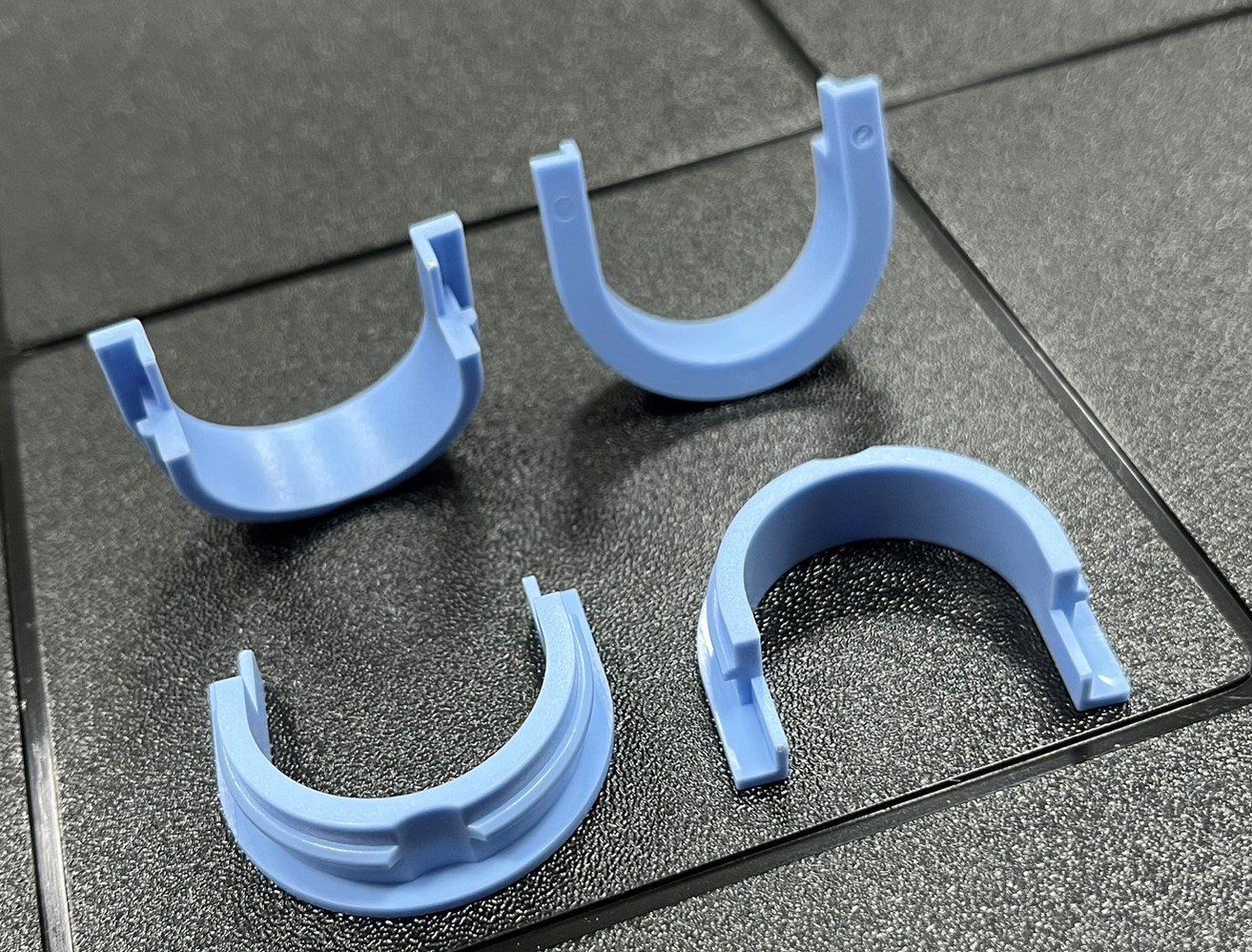 Three blue plastic rings are laying on a tiled floor