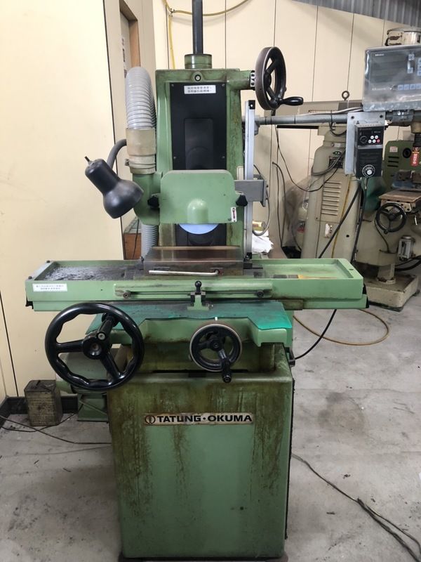 A green machine with a steering wheel is sitting in a room.