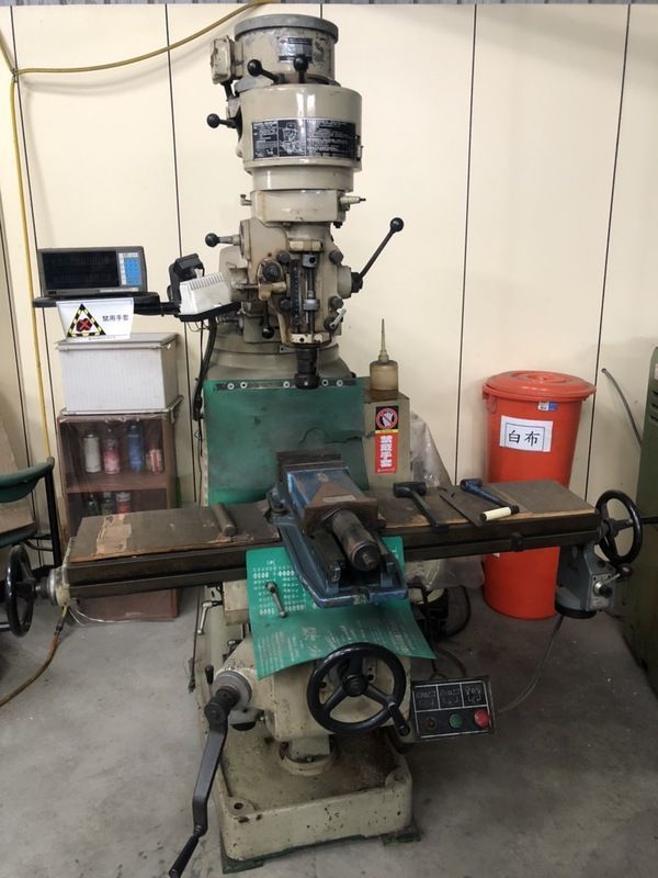 A machine is sitting in a room next to a red trash can.
