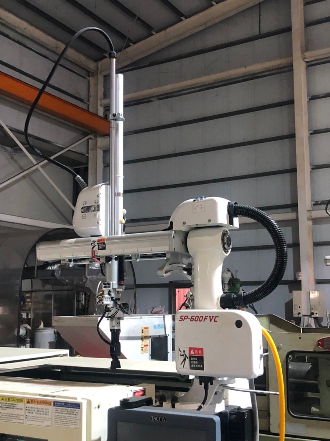 A robotic arm is sitting on top of a machine in a factory.