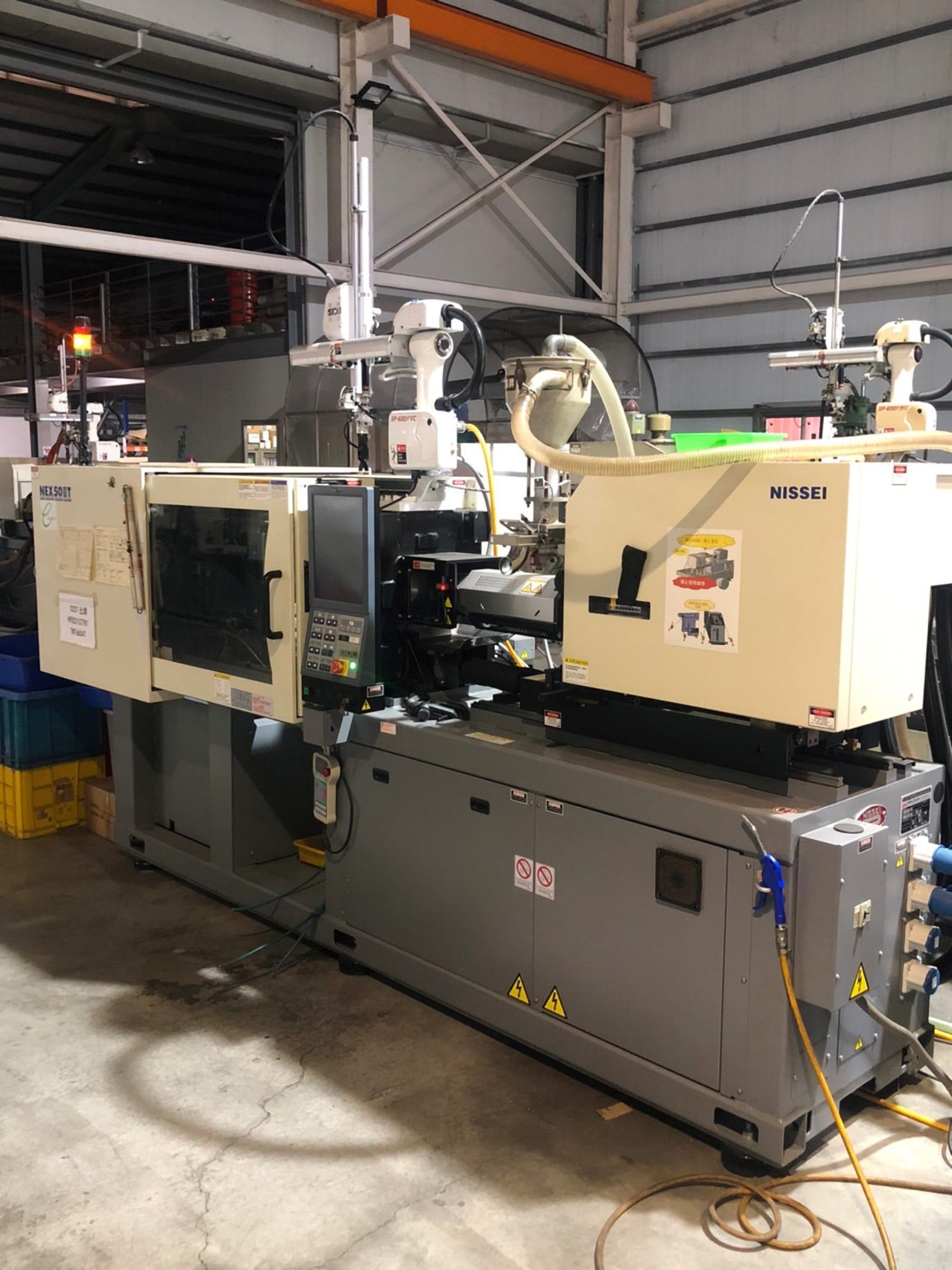 A large injection molding machine is sitting in a warehouse.