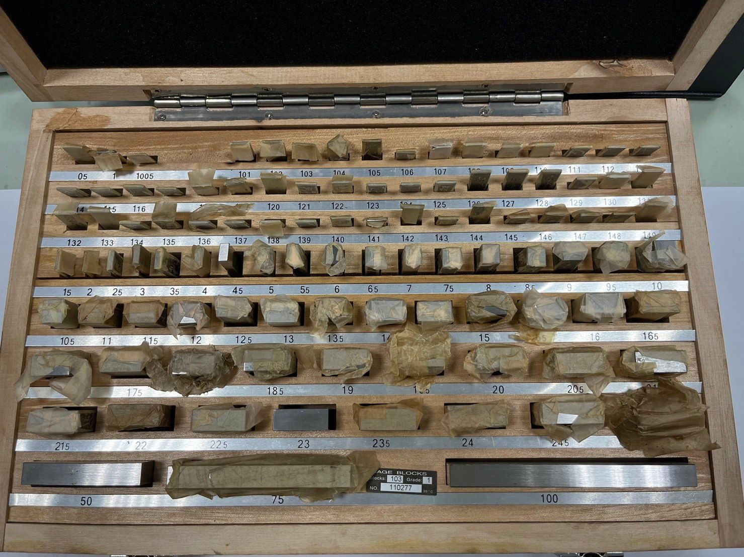 A wooden box filled with various pieces of metal