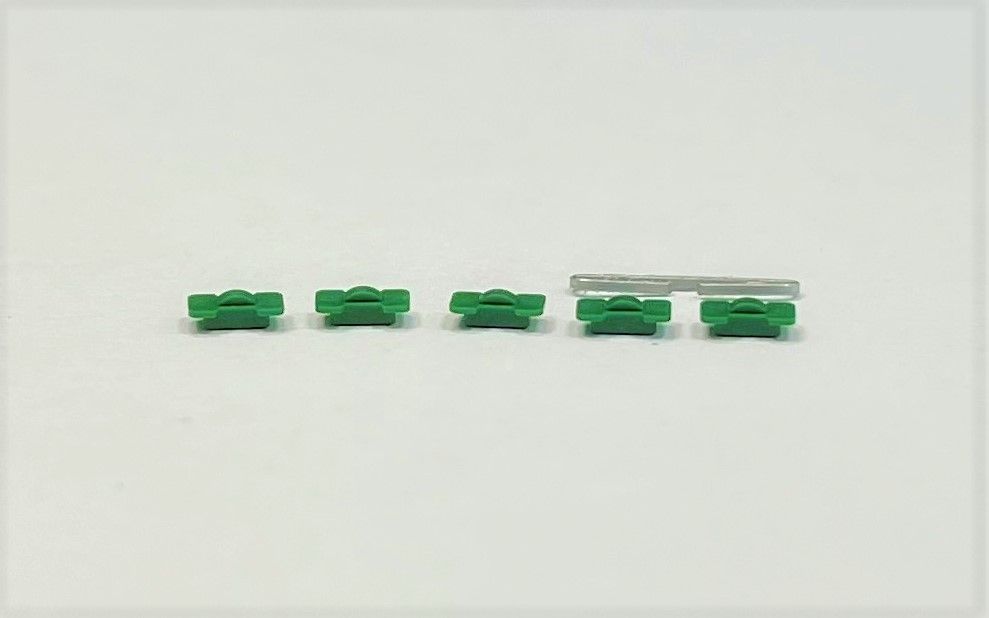 A row of green lego pieces on a white surface.