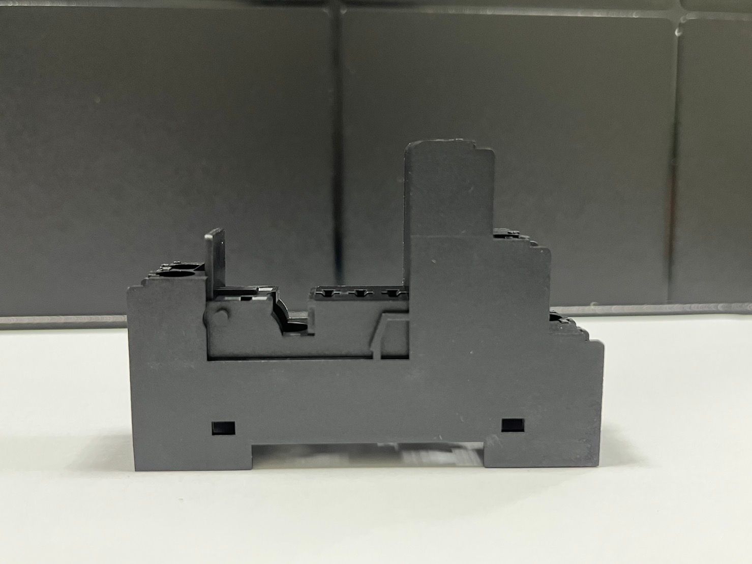 A black electrical device is sitting on a white surface
