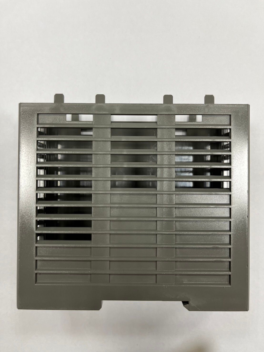 A gray plastic cage is sitting on a white surface.
