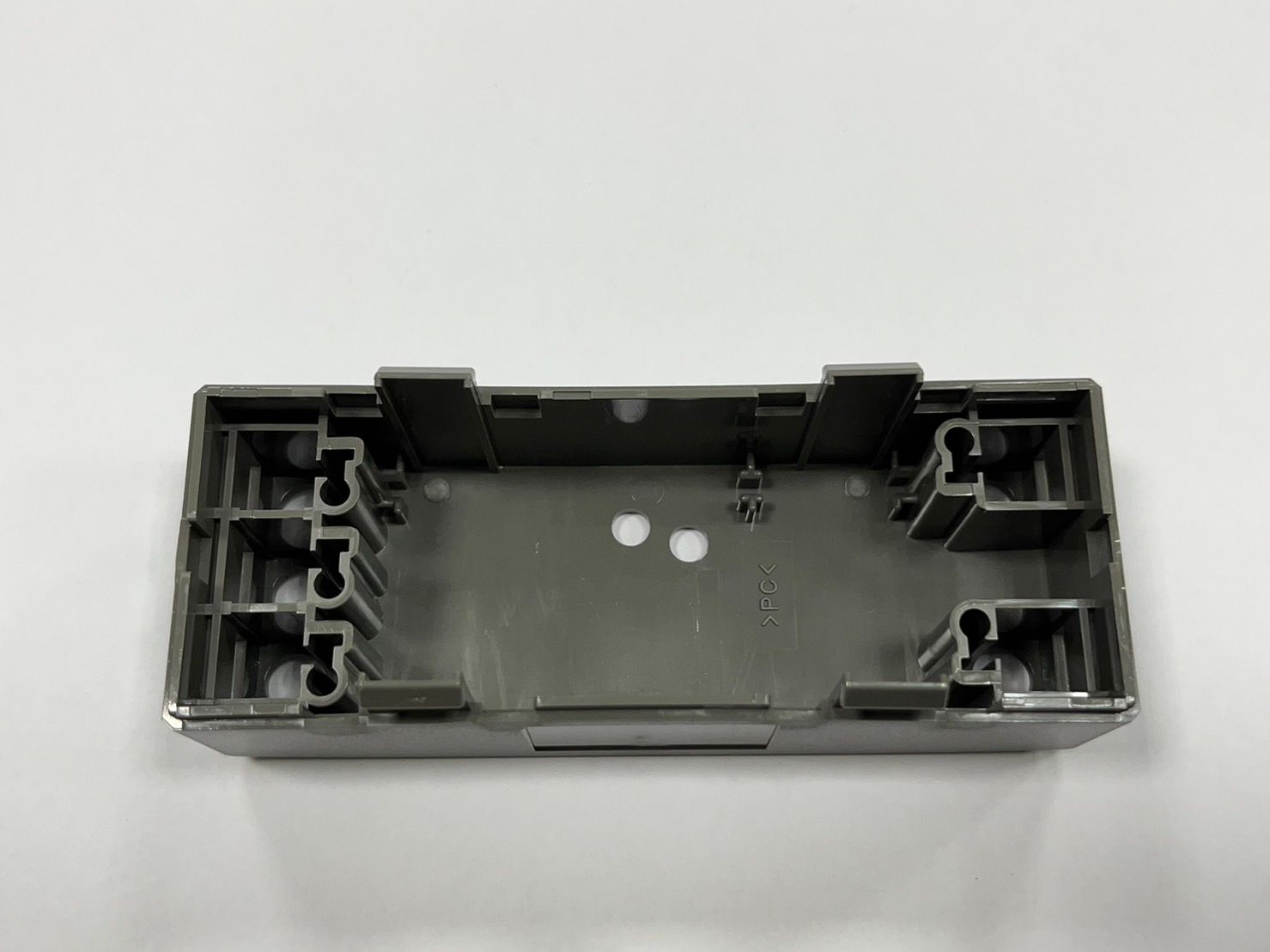 A gray plastic box is sitting on a white surface.