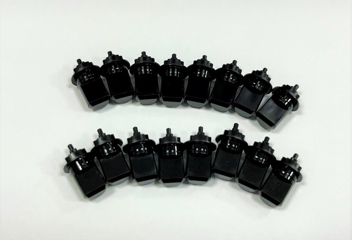 A bunch of black bottles are lined up in a row