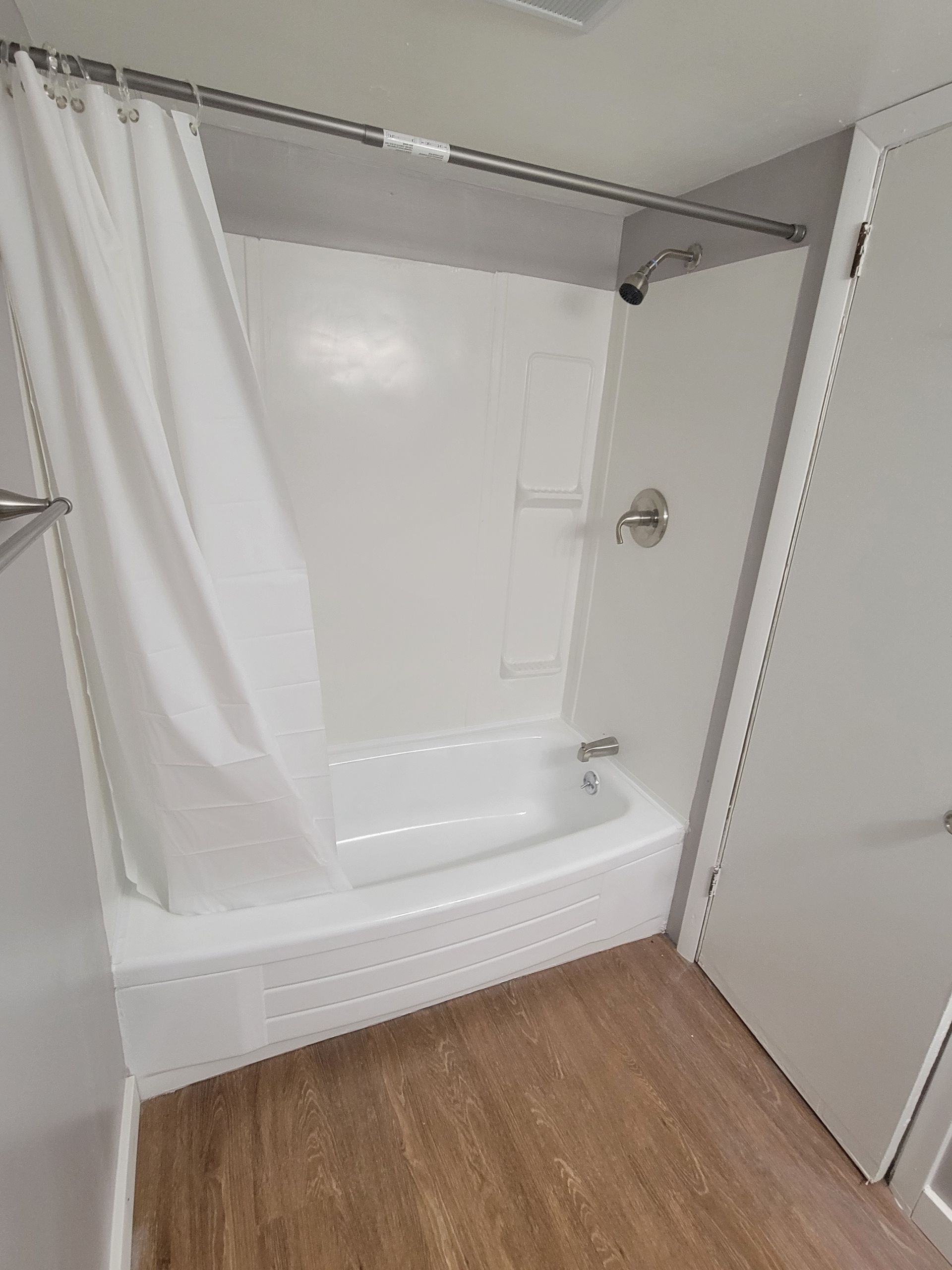 A bathroom with a bathtub and shower curtain.