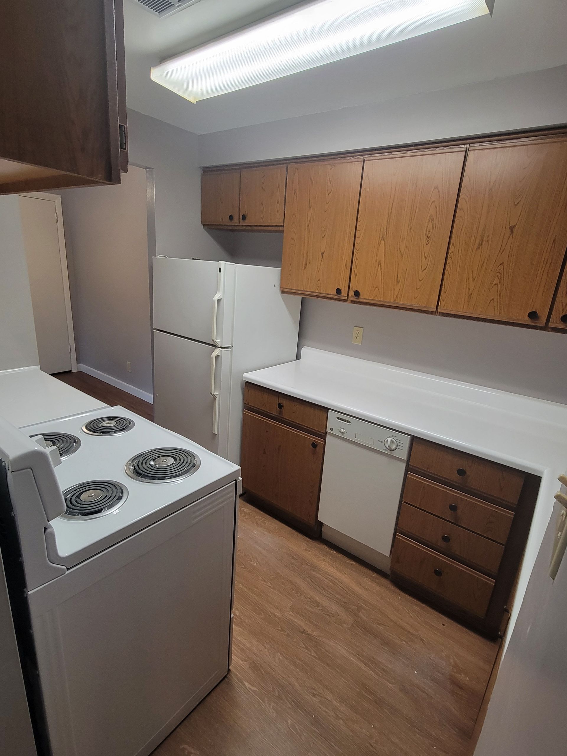 A kitchen with a stove , refrigerator , dishwasher and cabinets.