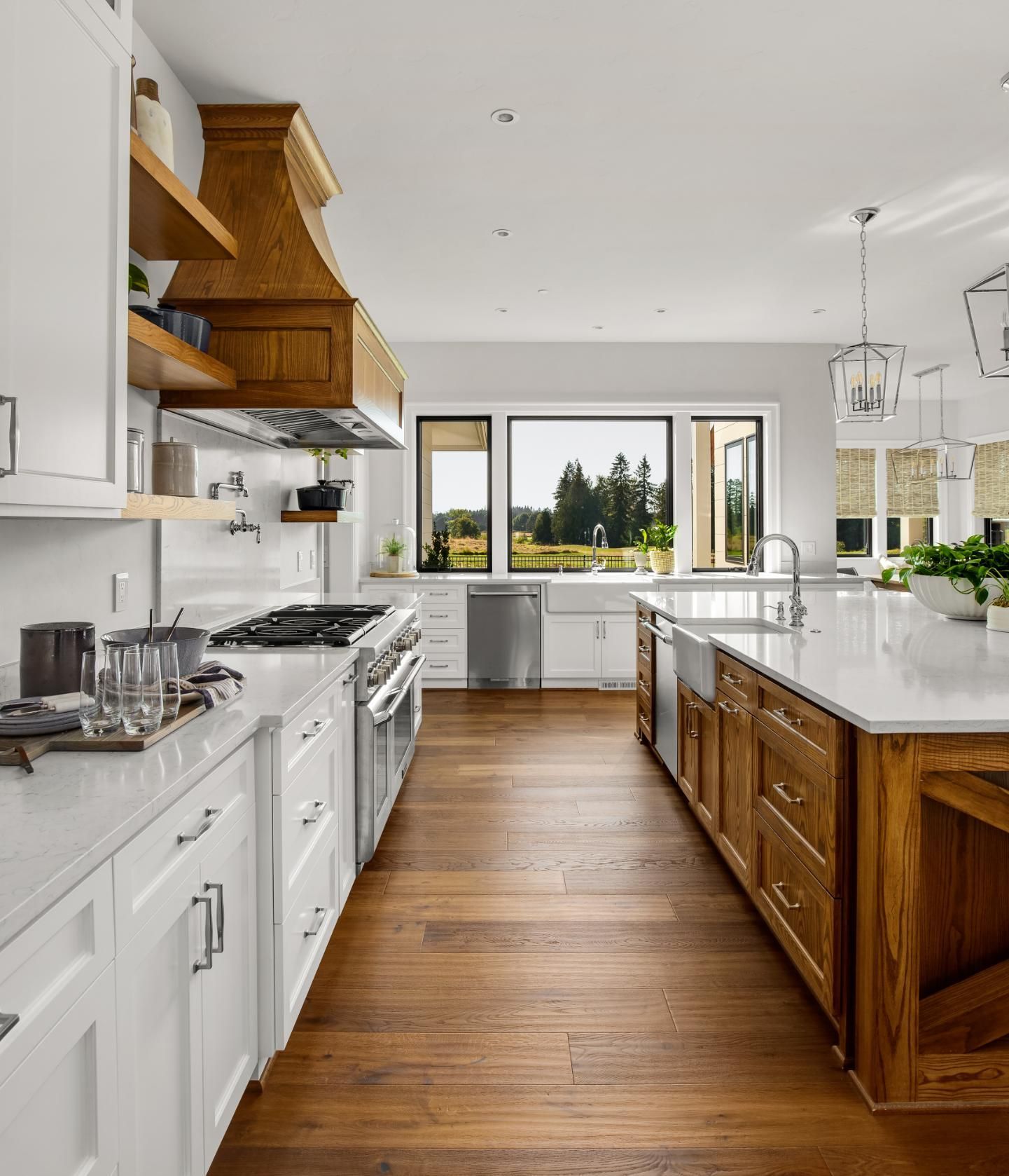 Bright, modern kitchen with wood cabinets, white countertops, and large window overlooking a field.