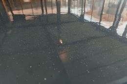 Dark, shiny floor with reflections, speckles, and a blurred, bright shape in the center.