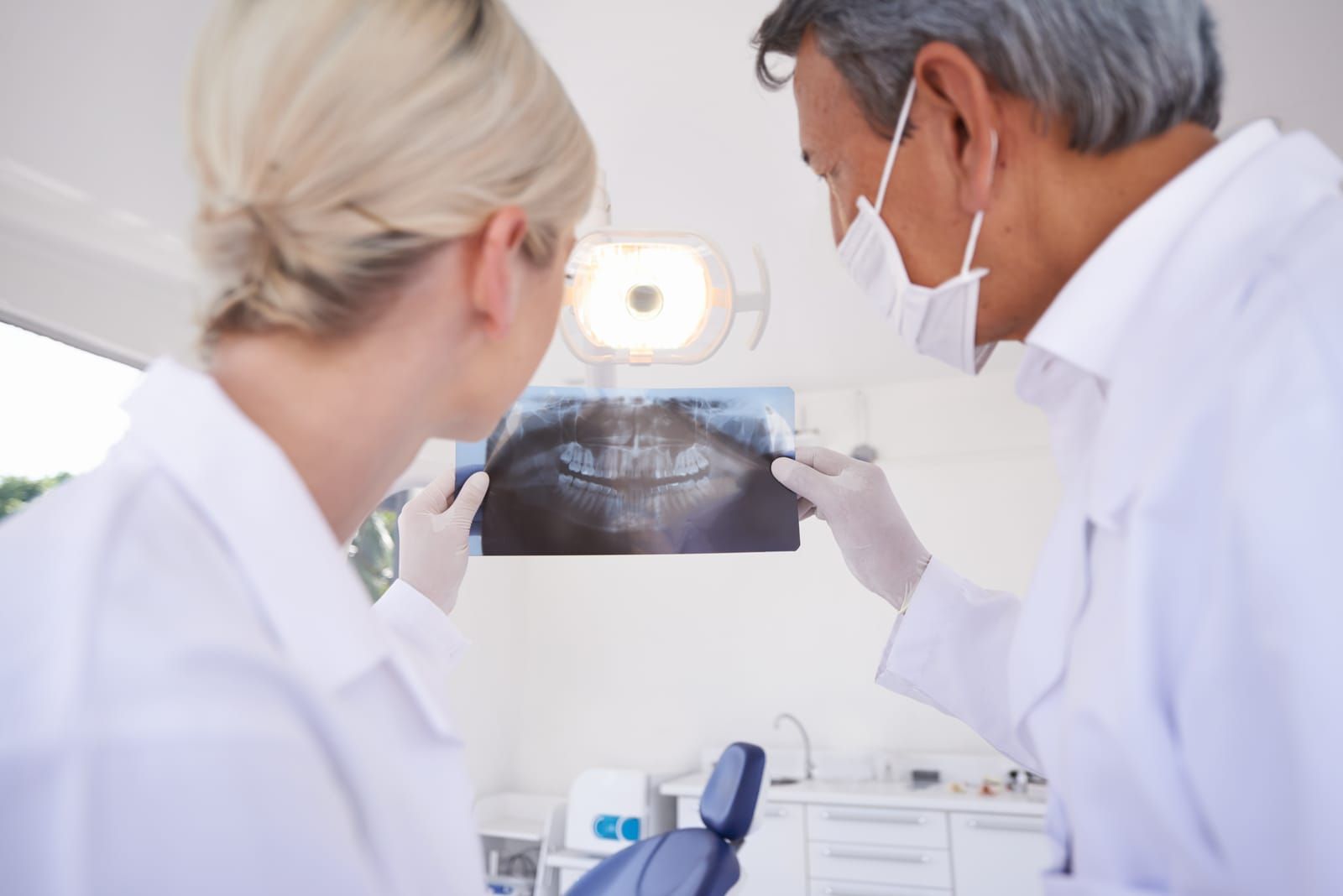 male-and-female-physician-holding-a-dental-scan-of-a-patient