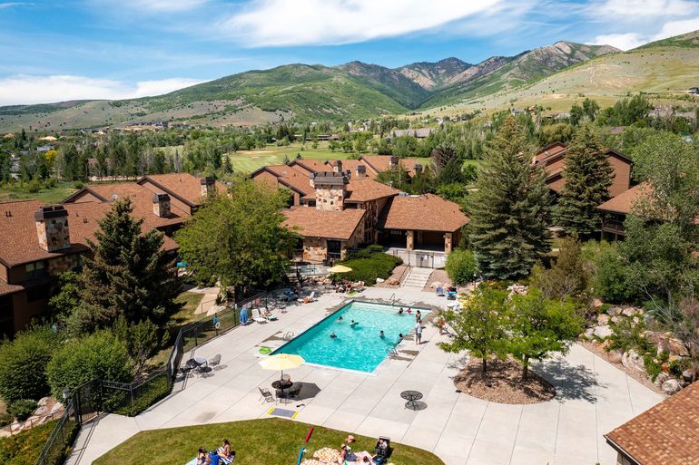 An aerial view of a large swimming pool surrounded by buildings and trees.