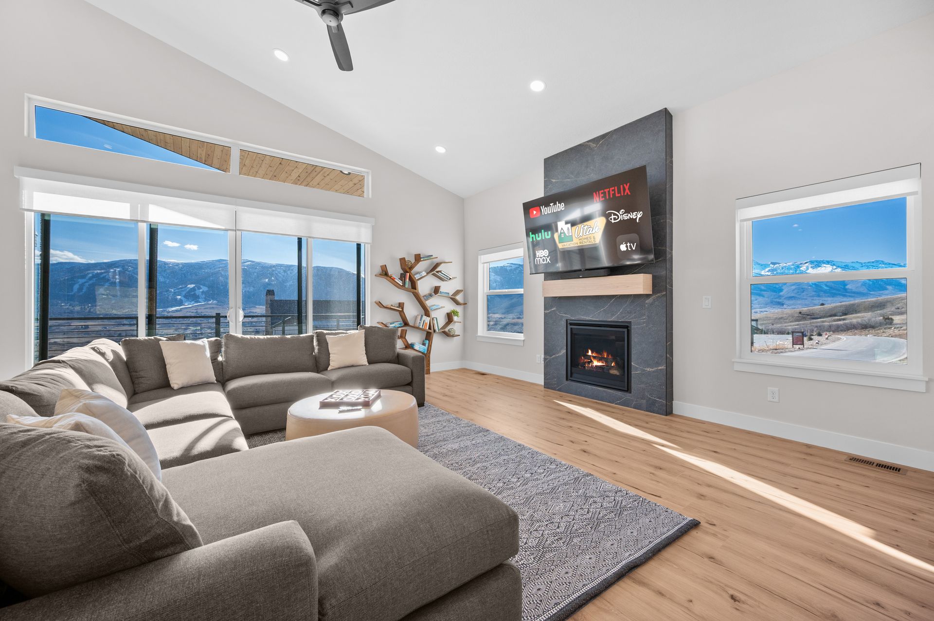 One of the vacation homes we have available for you to enjoy. Shows mountain view, fireplace, large smart TV, fireplace, and living room furniture.