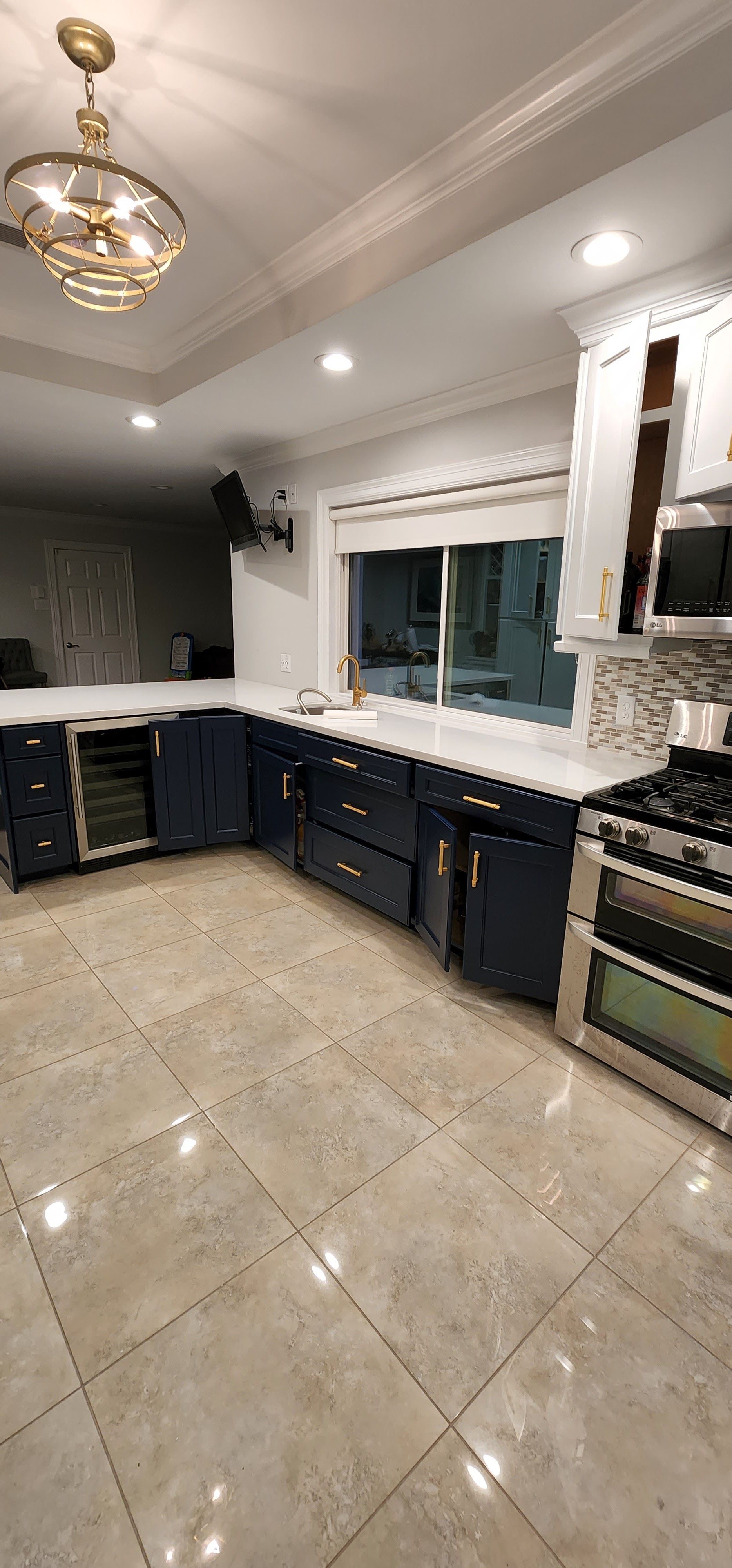 Modern kitchen with blue cabinets, white countertops, and stainless steel appliances.