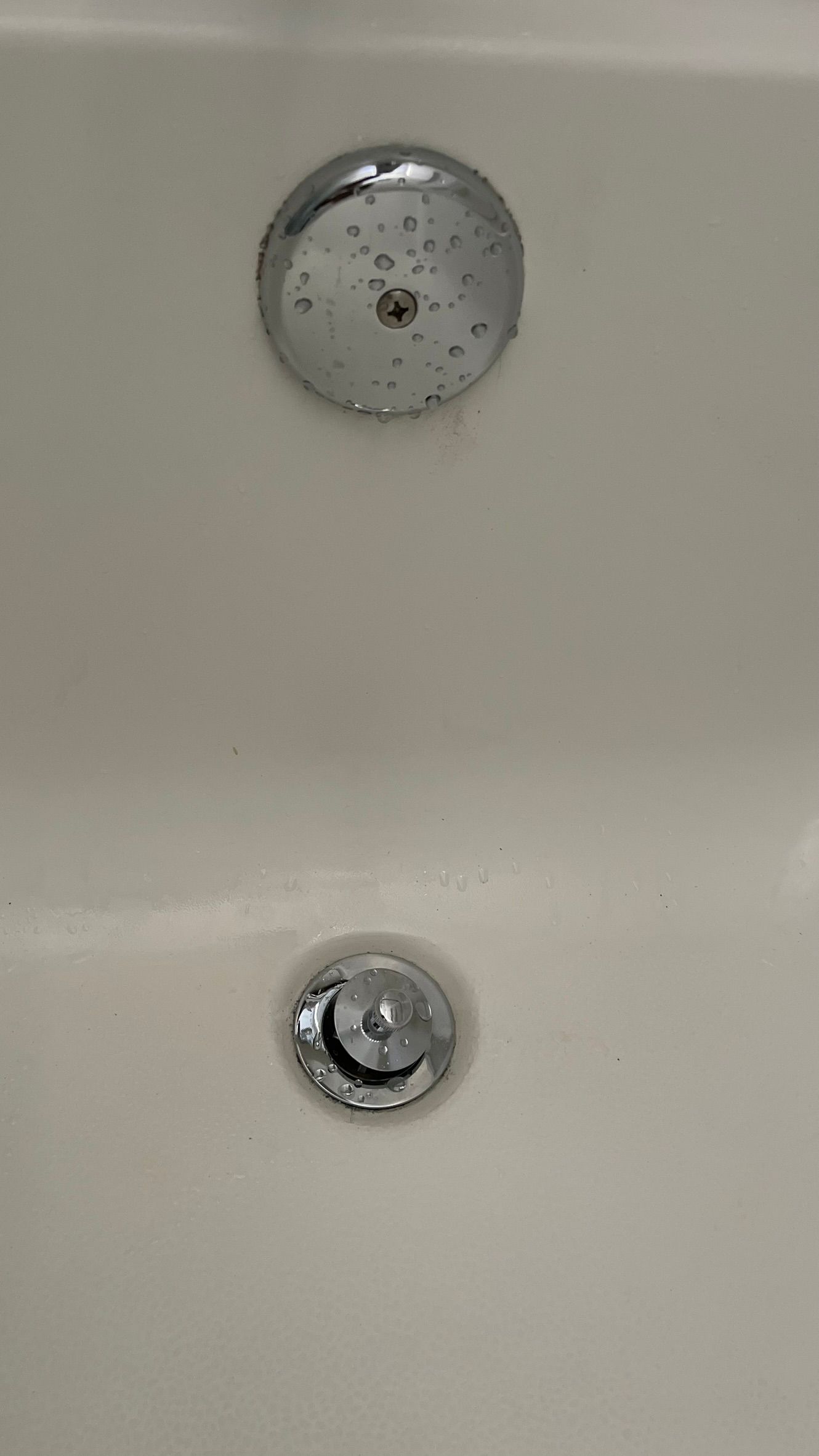 Close-up of a white bathtub with a chrome faucet and drain.