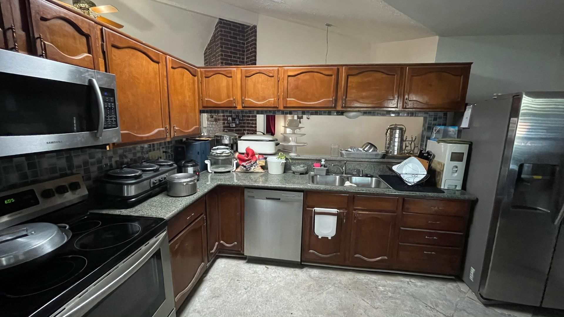 Kitchen with brown cabinets, stainless steel appliances, and granite countertops.
