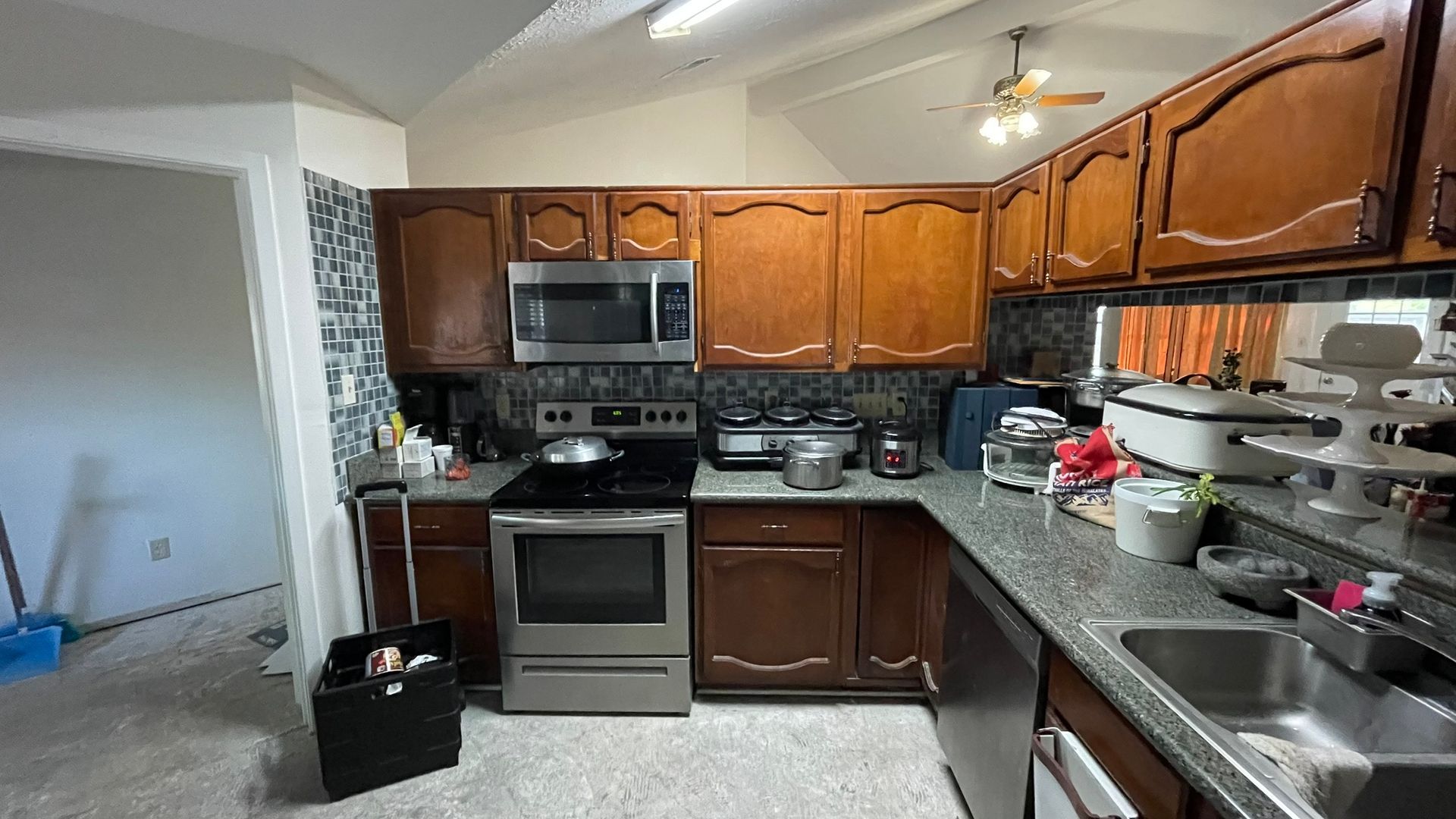 Kitchen with brown cabinets, stainless steel appliances, granite countertops.
