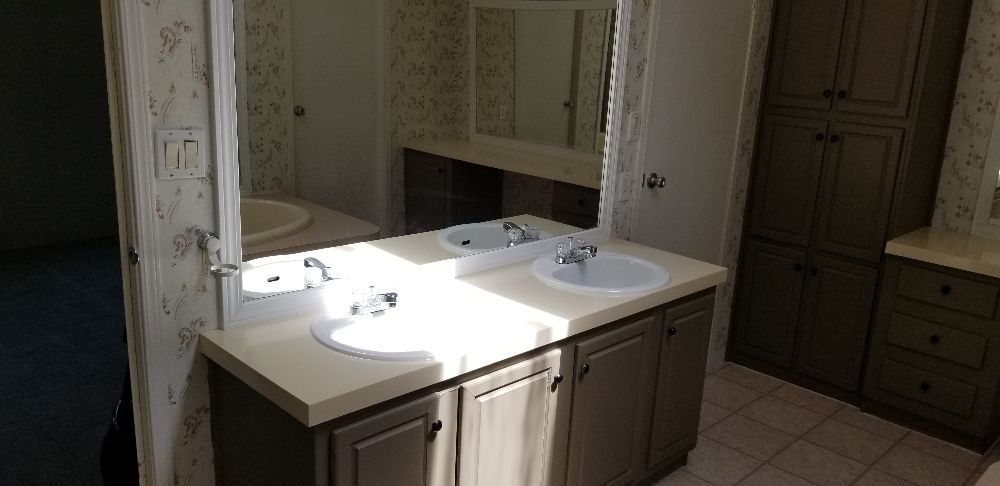 Bathroom with double sinks, large mirror, and cabinets.