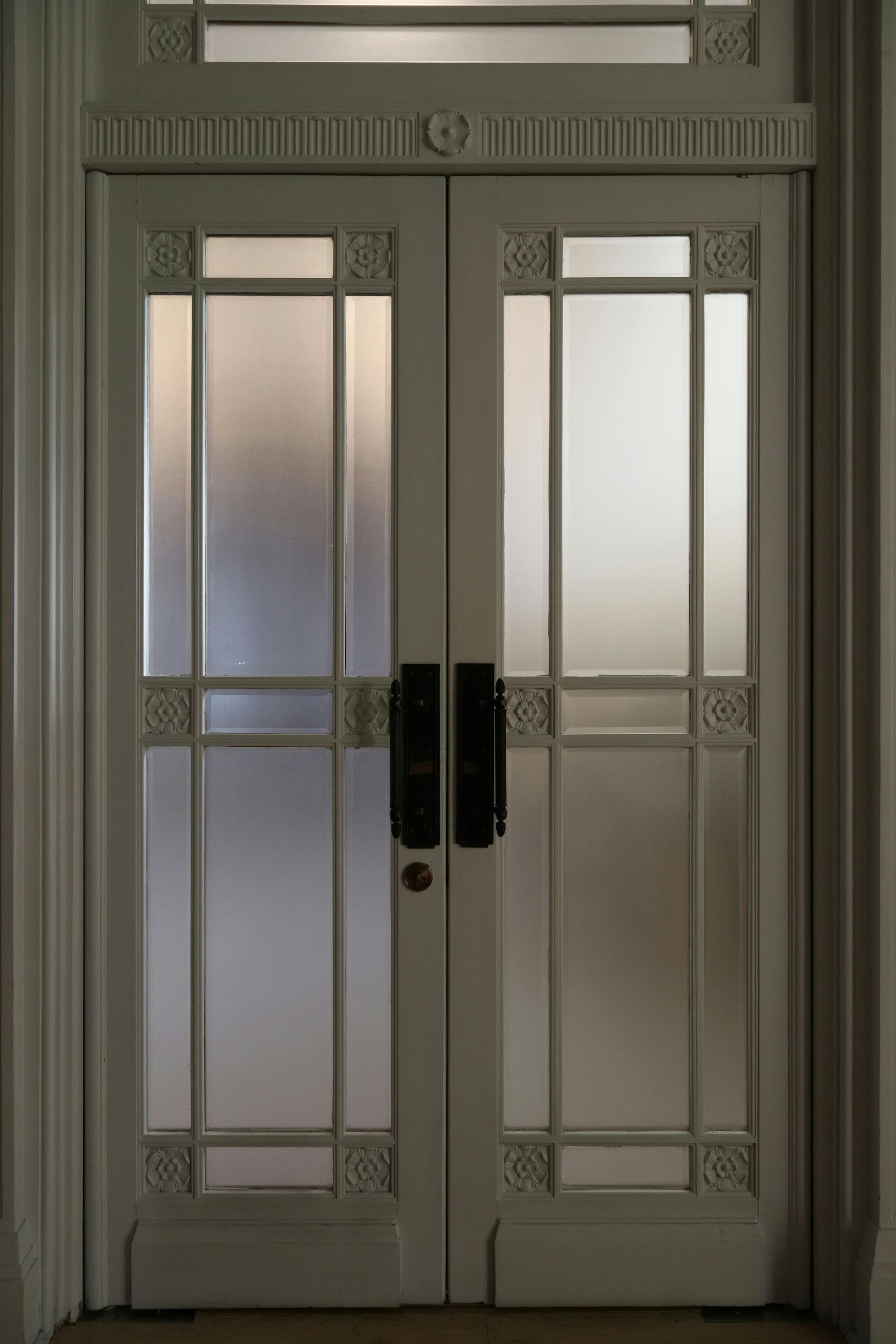 Wooden ladder set up in room, paint supplies on drop cloths, white walls and wood floors.