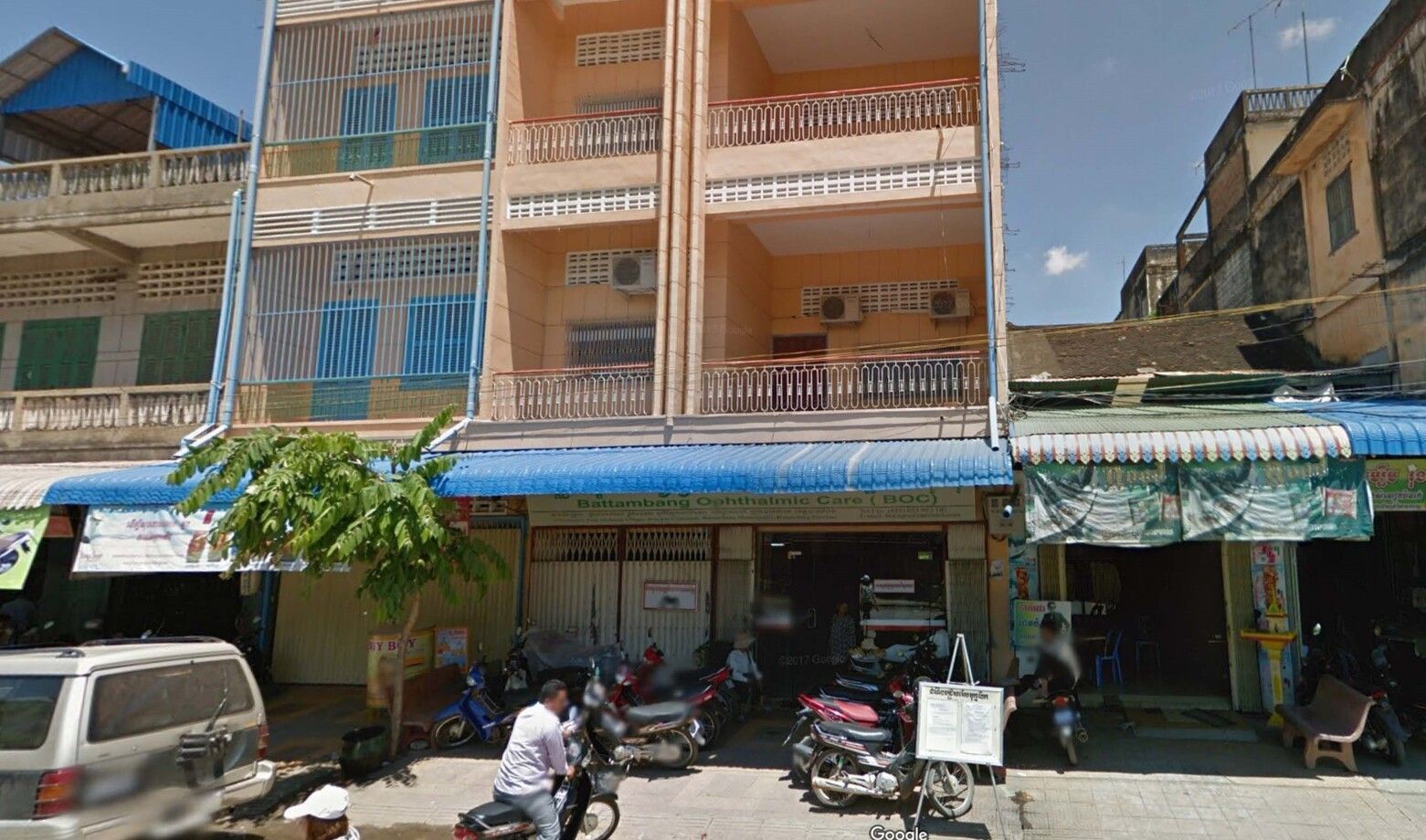 A man is riding a motorcycle in front of a building