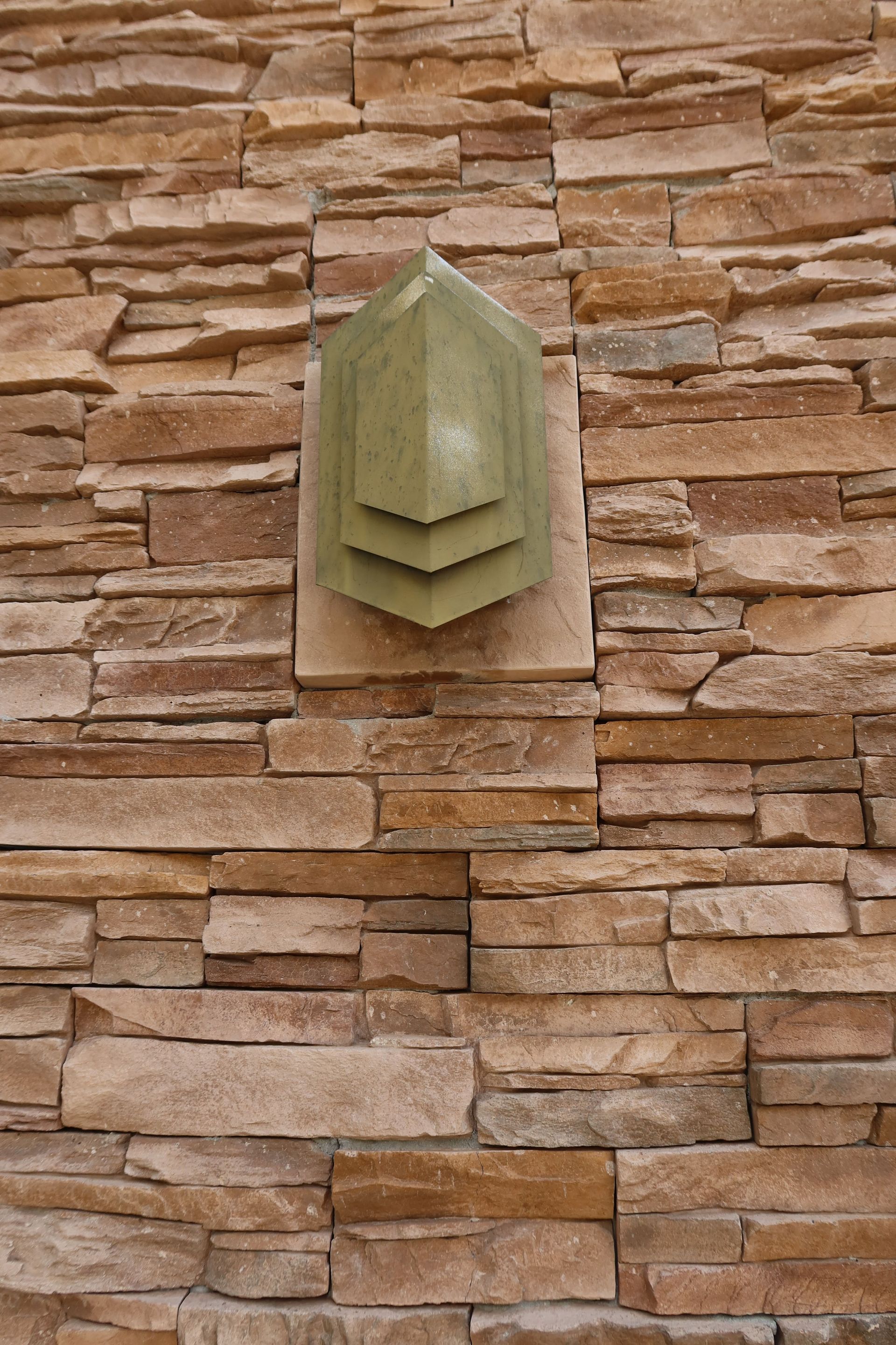 A brick wall with a triangle on top of it