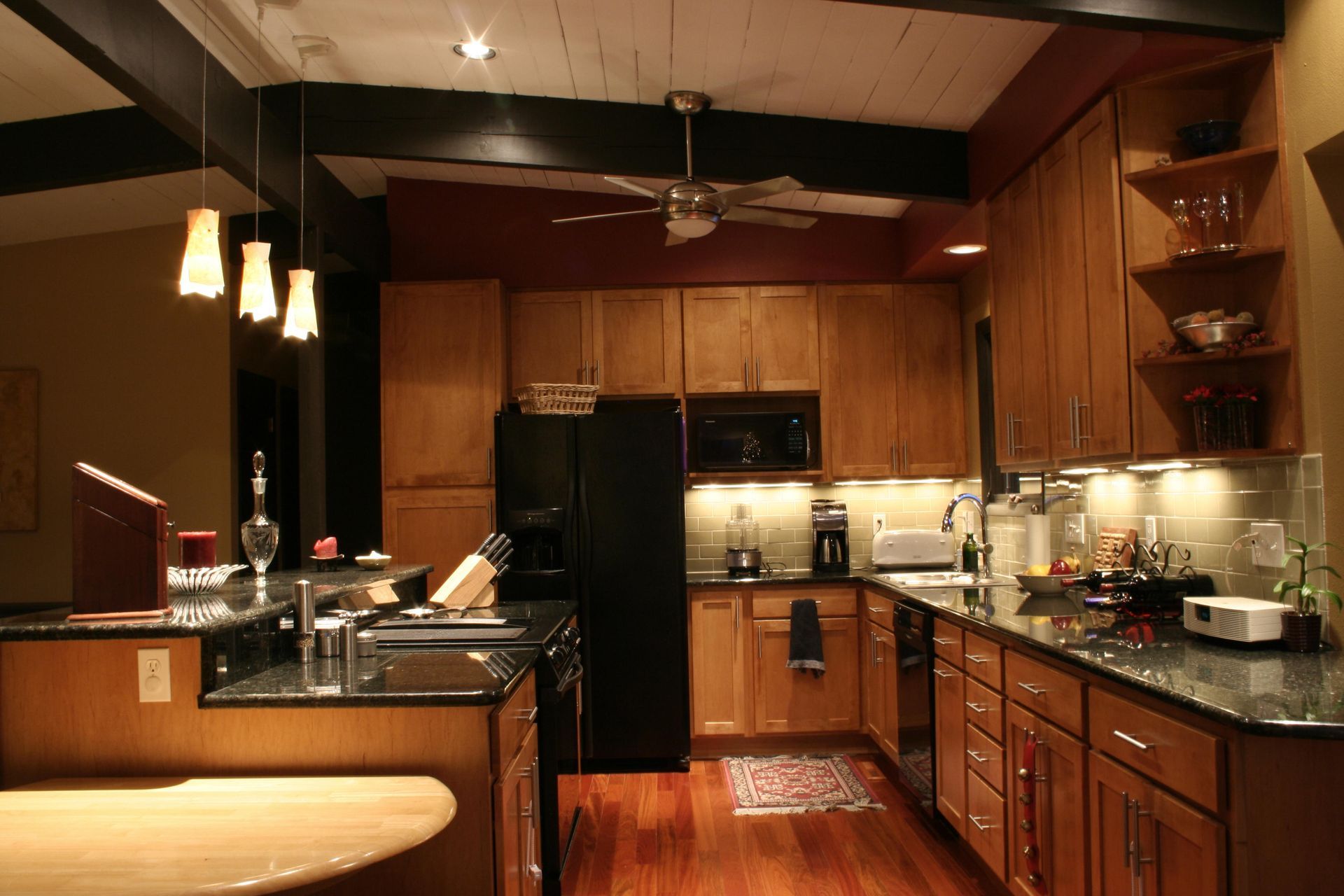 A kitchen with wooden cabinets and a black refrigerator
