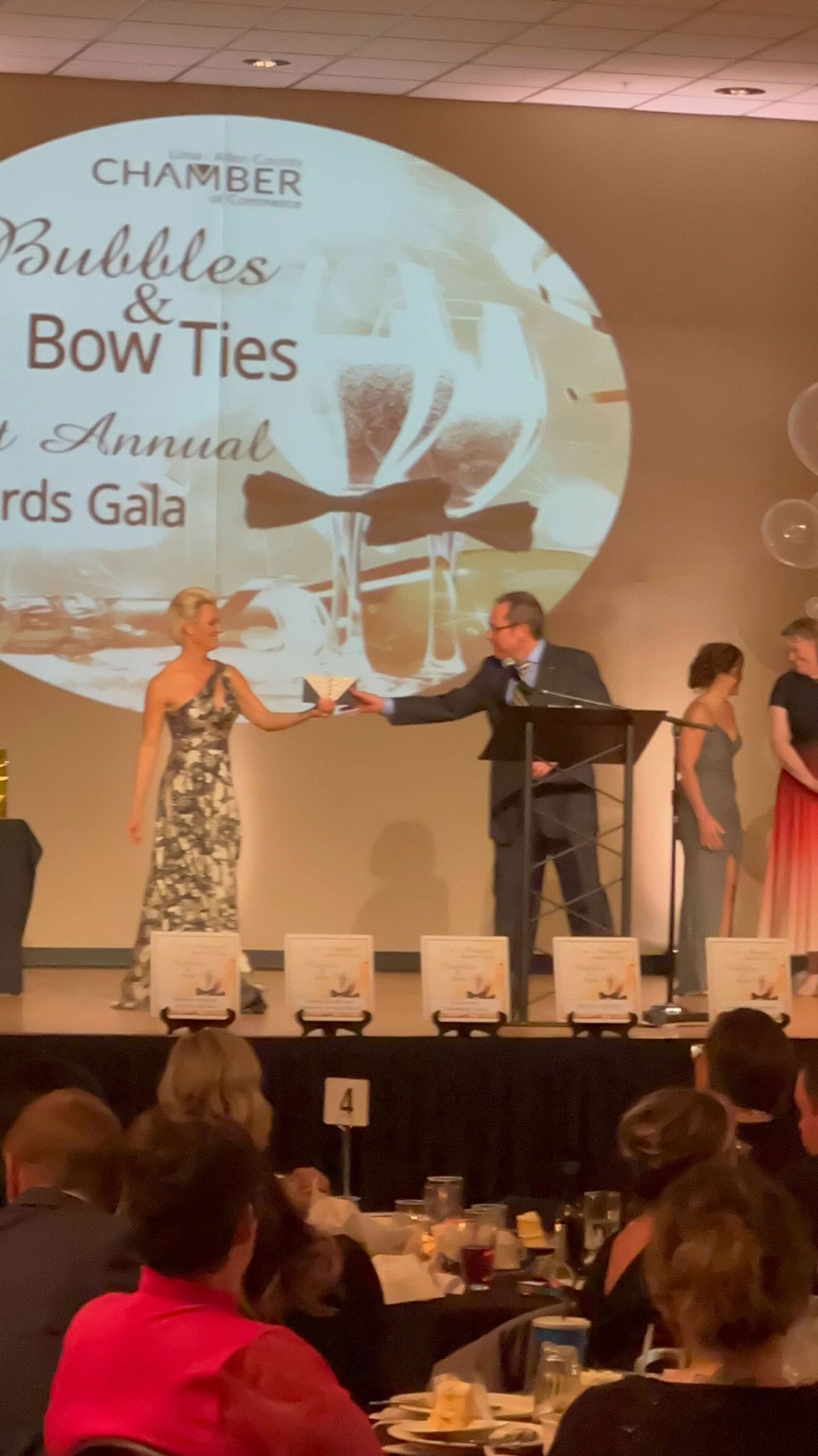 A woman giving an envelope to a man — Thryv Foundation