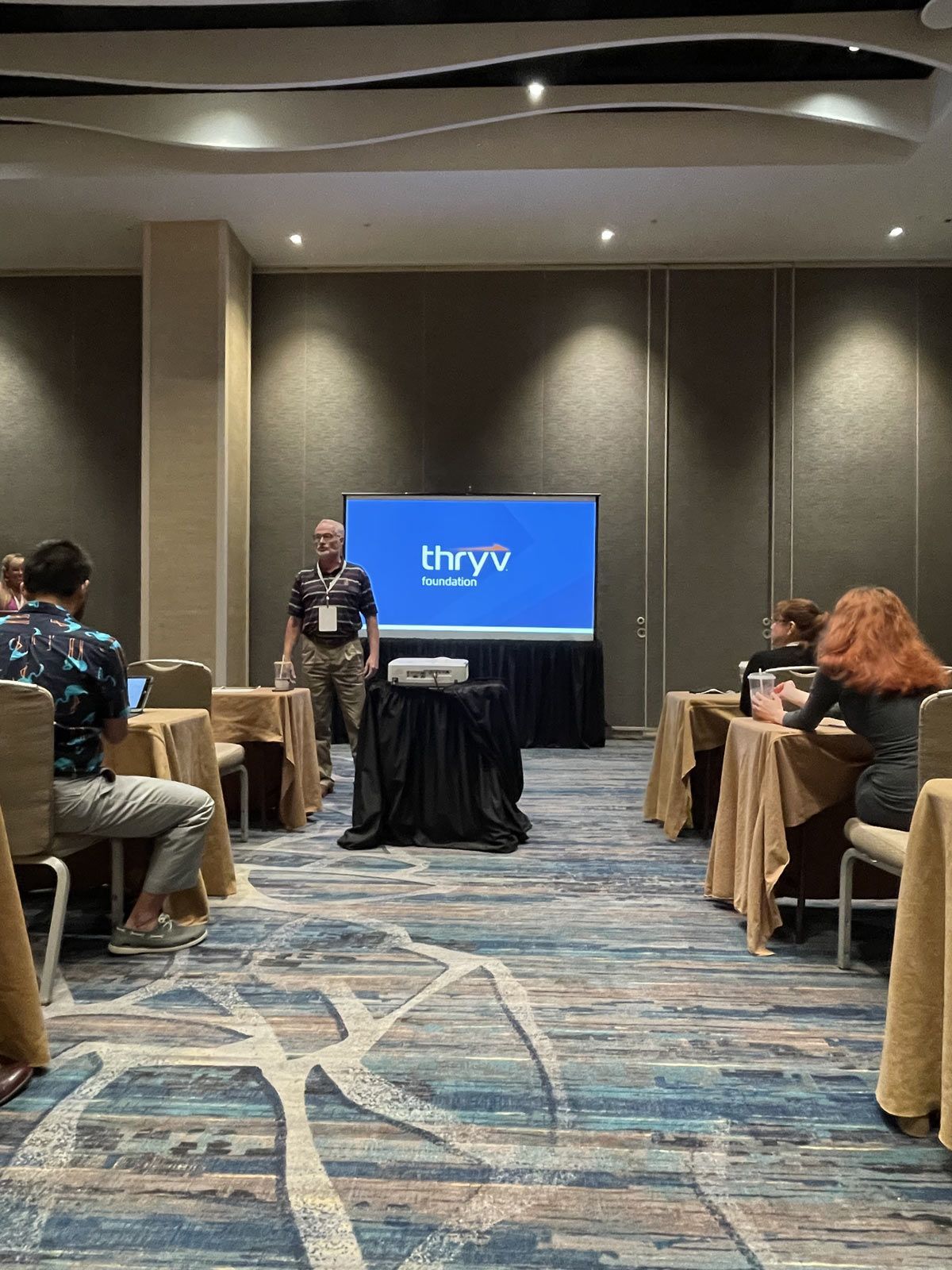 Man in a room standing in front of a large screen — Thryv Foundation