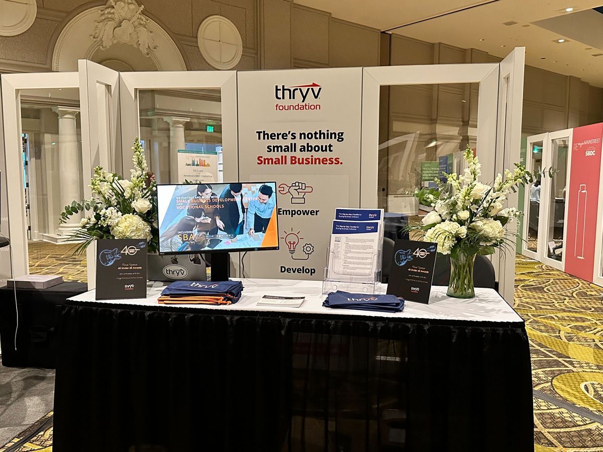 A table with a computer and flowers — Thryv Foundation