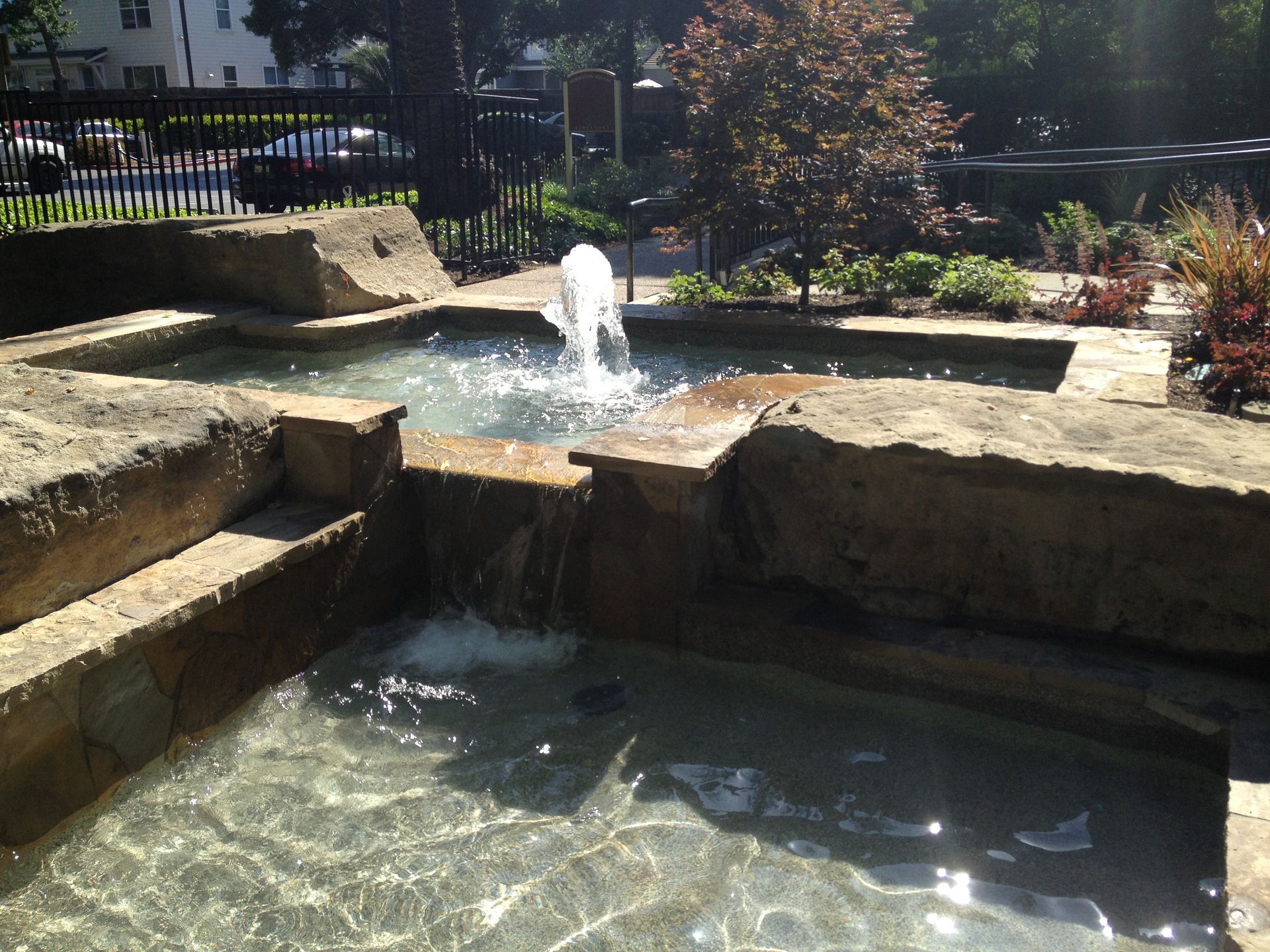 Stone garden fountain with water bubbling into a small pond