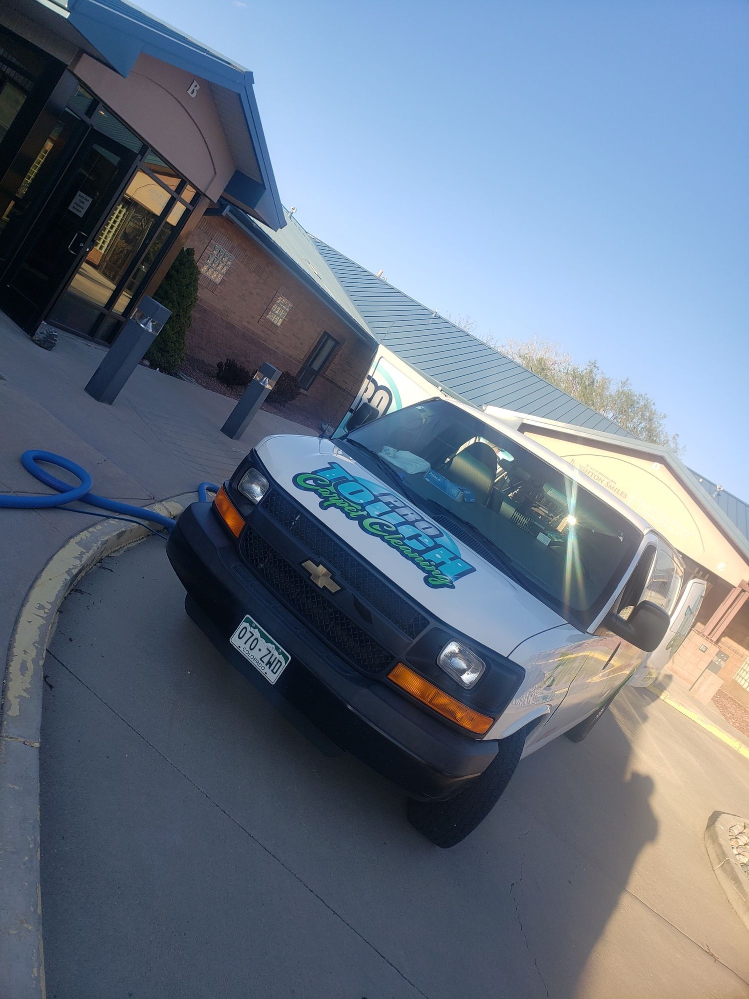 A white van is parked in front of a building.