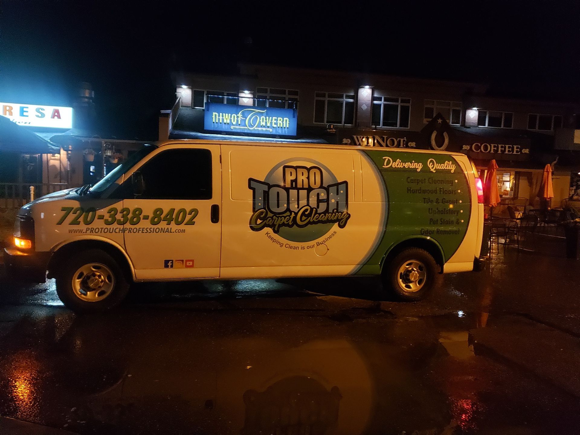 A pro touch van is parked in front of a building at night