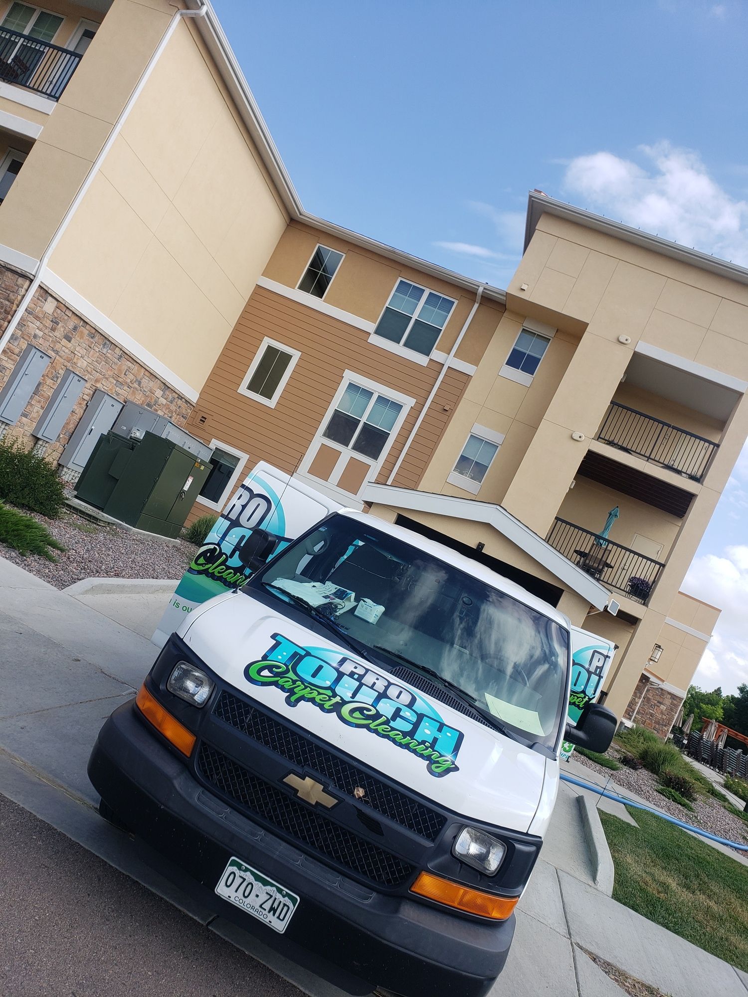A white van is parked in front of a building.