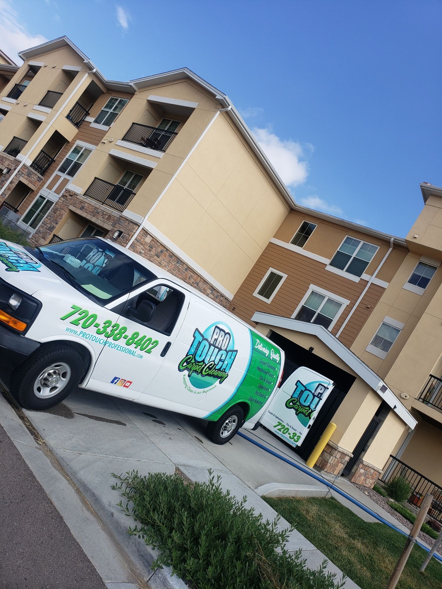 A white van is parked in front of a building.