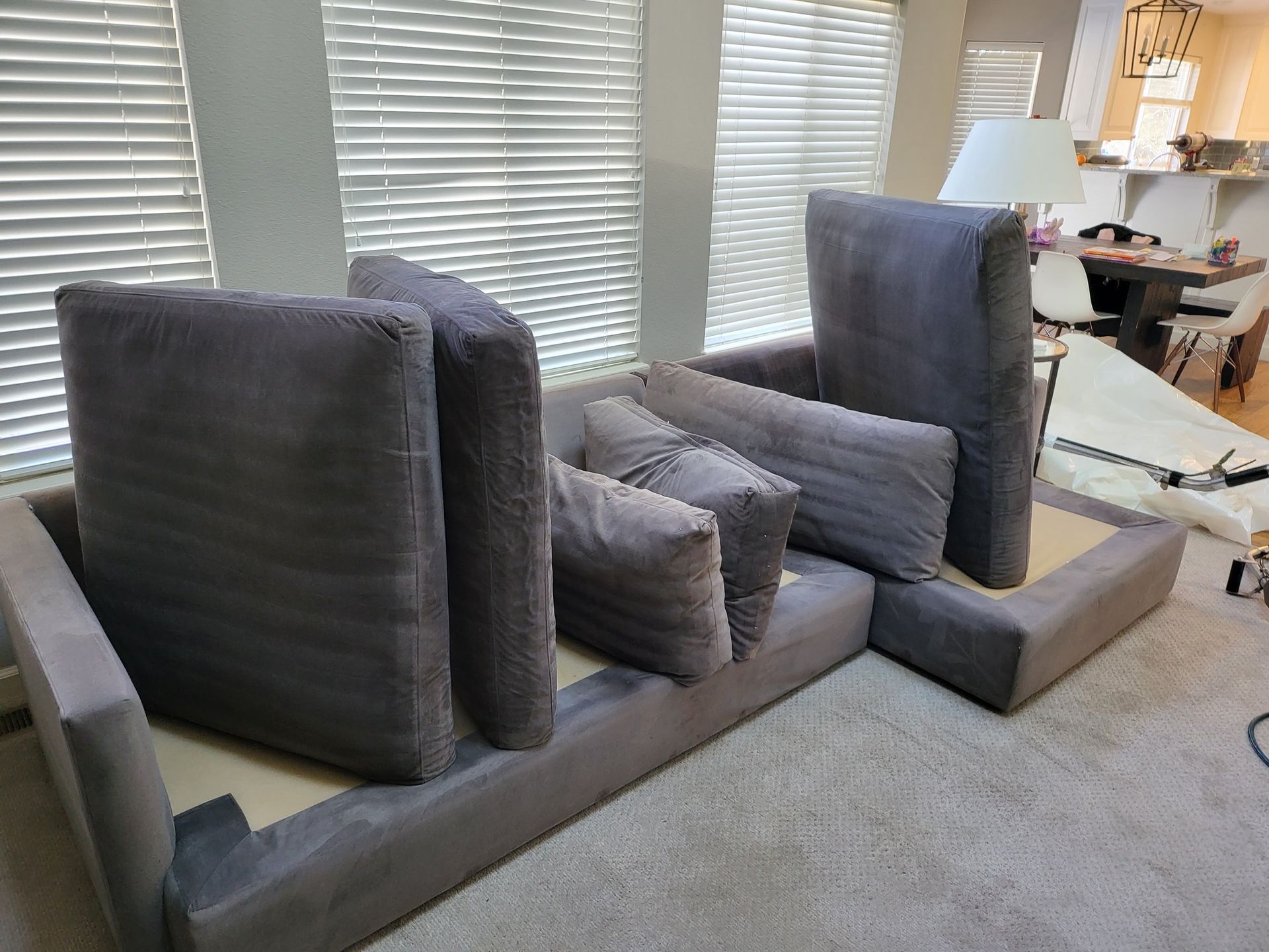 A gray sectional couch is sitting in a living room next to a window.