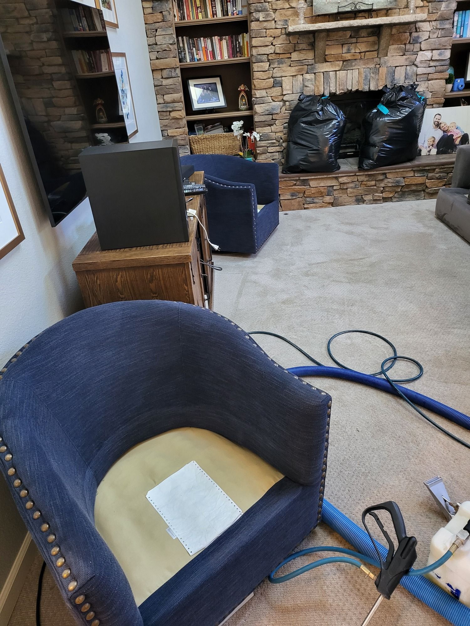 A blue chair is sitting in a living room next to a fireplace.