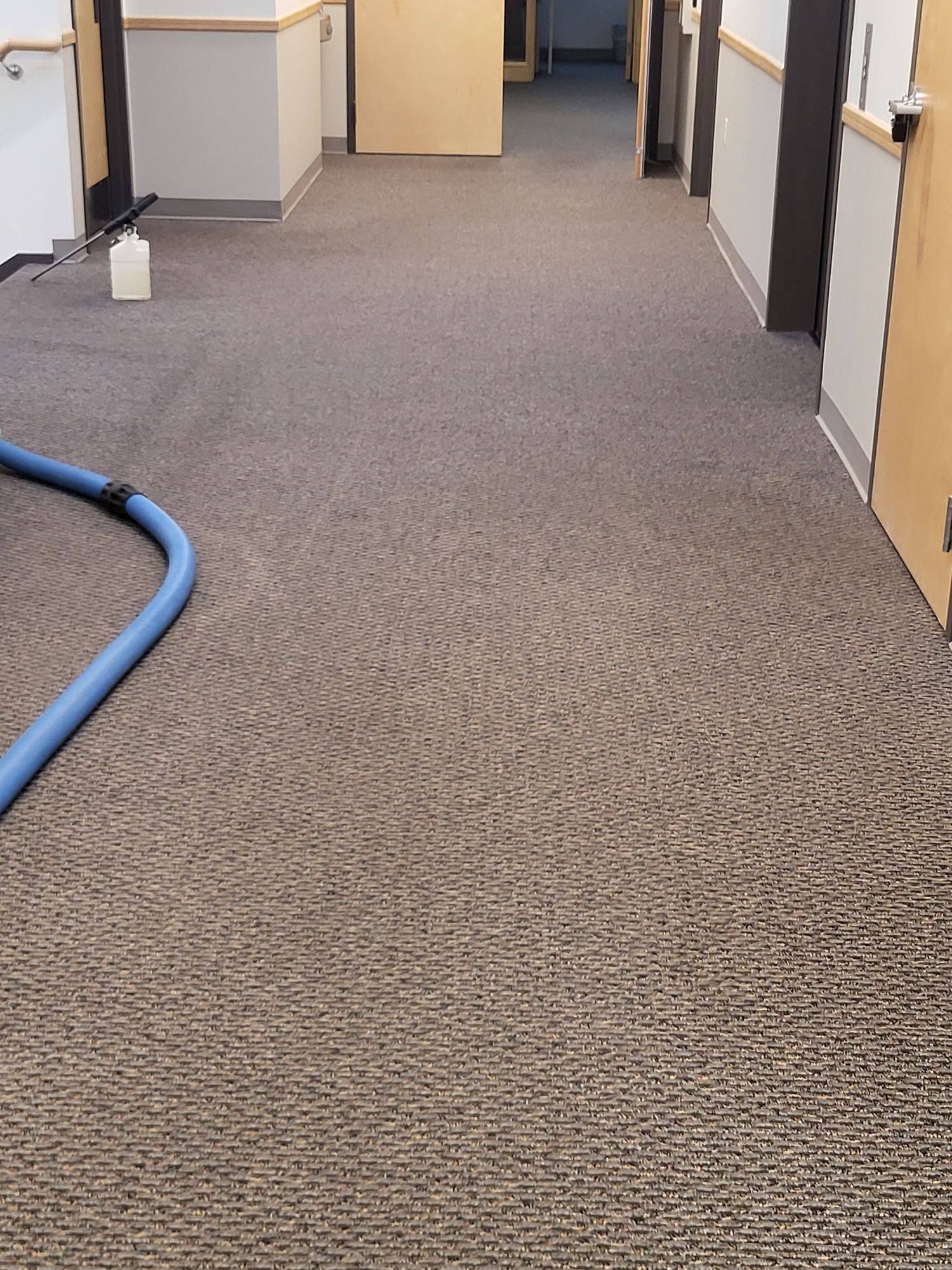 A hose is sitting on the floor of a hallway.