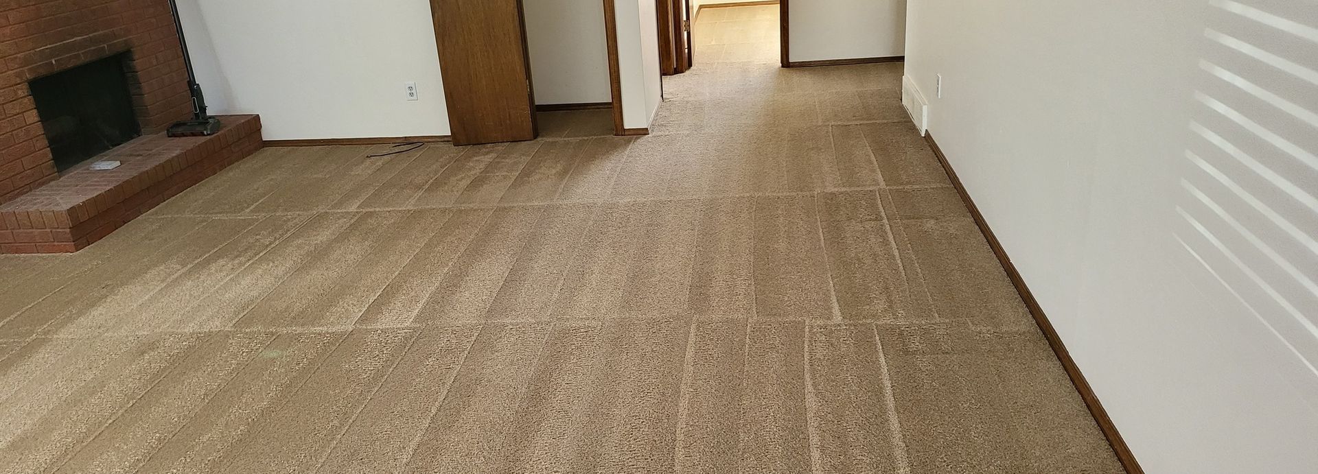 A living room with a fireplace and a carpeted floor.