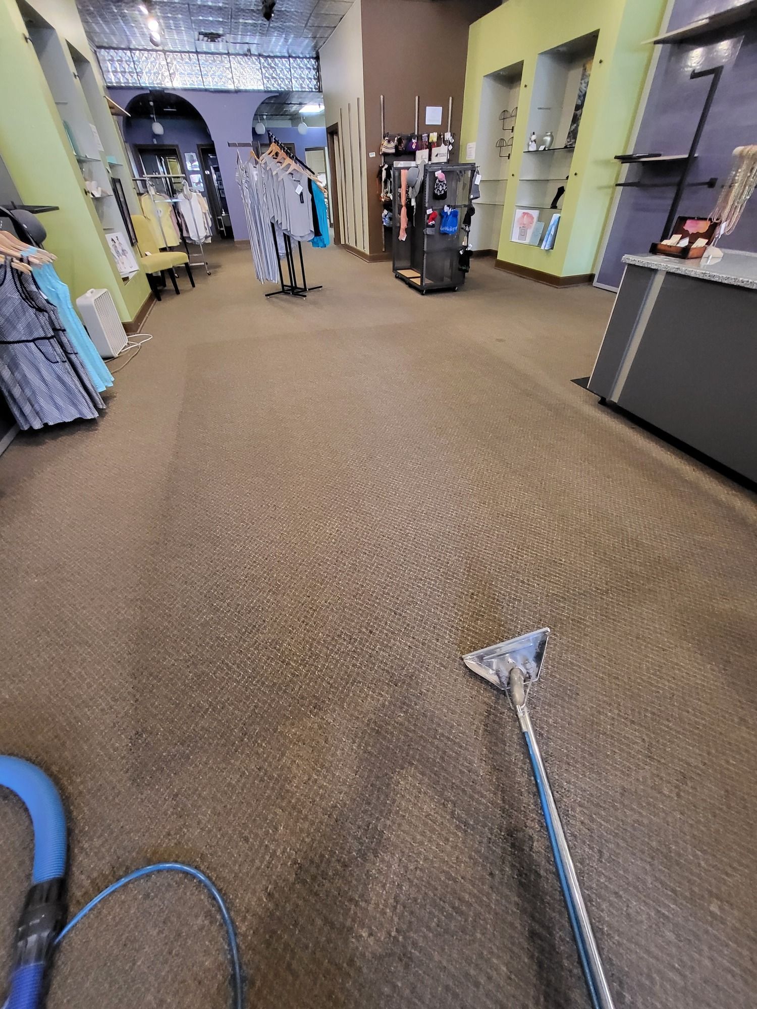 A vacuum cleaner is being used to clean a carpet in a store.