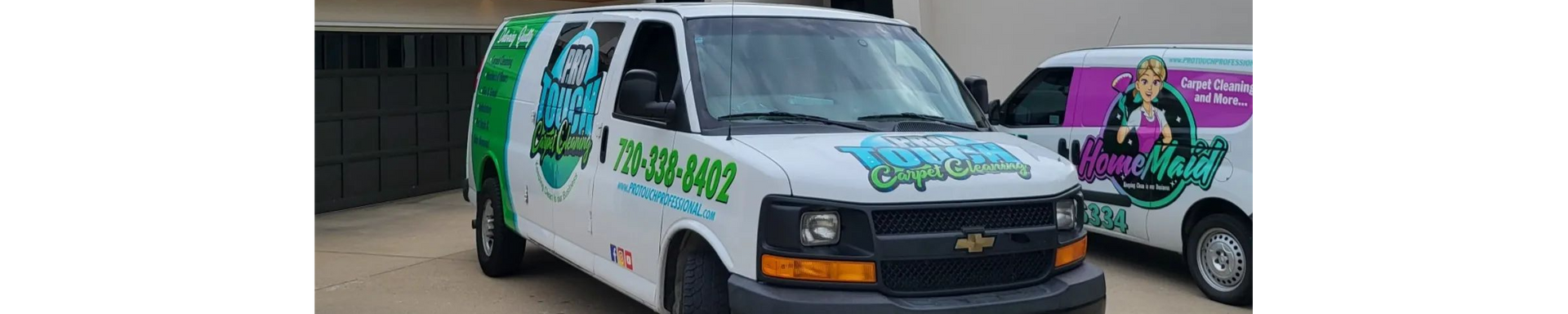 Two vans are parked next to each other in a driveway.