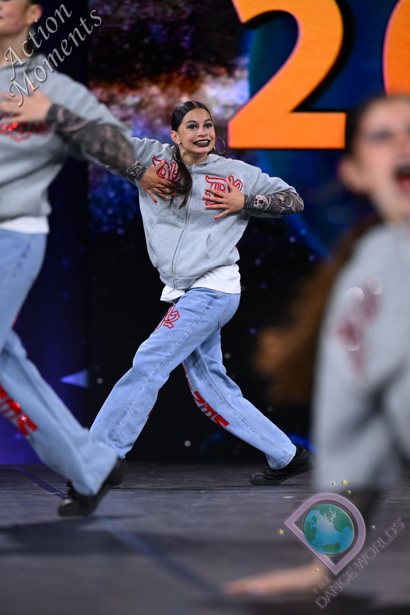 A group of people are dancing in front of a large number 2