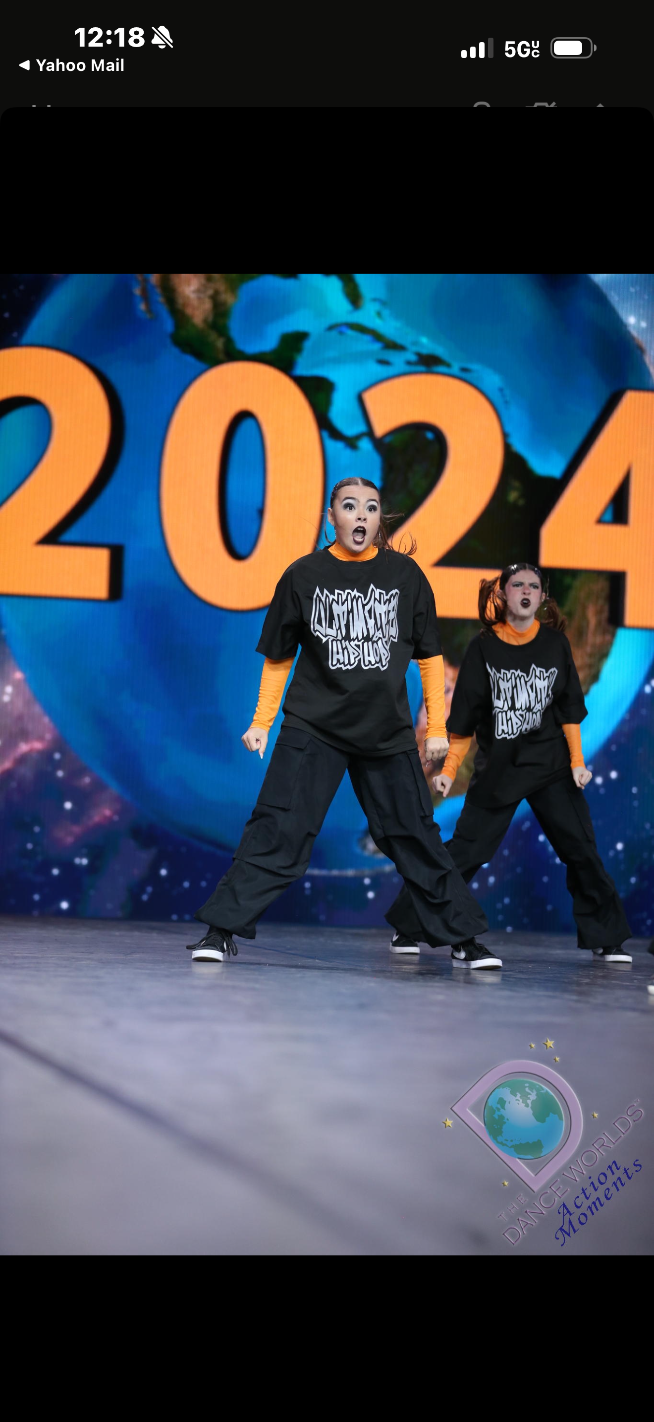 A couple of people are dancing in front of a sign that says 2024.