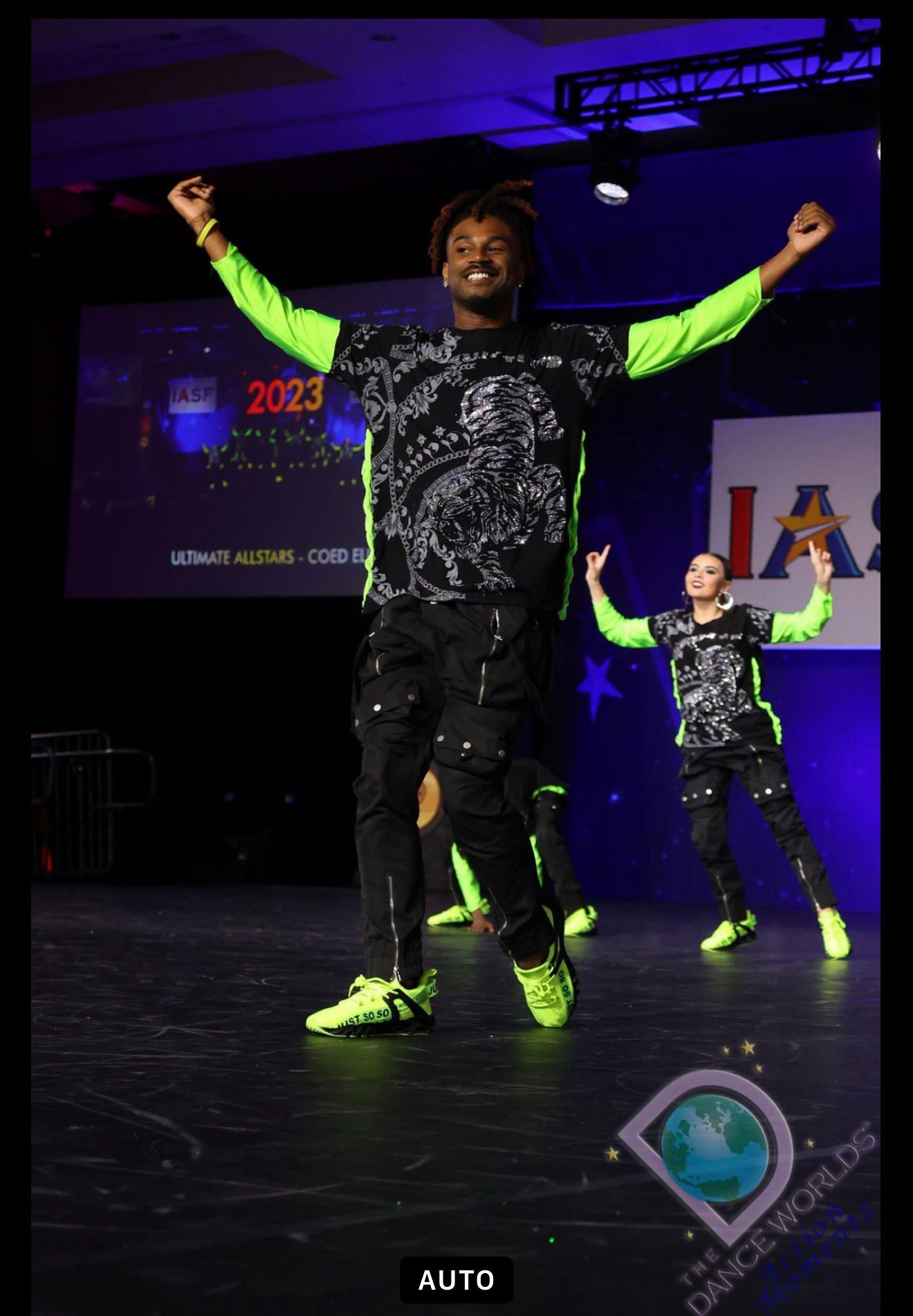 A man in a green shirt is dancing on a stage