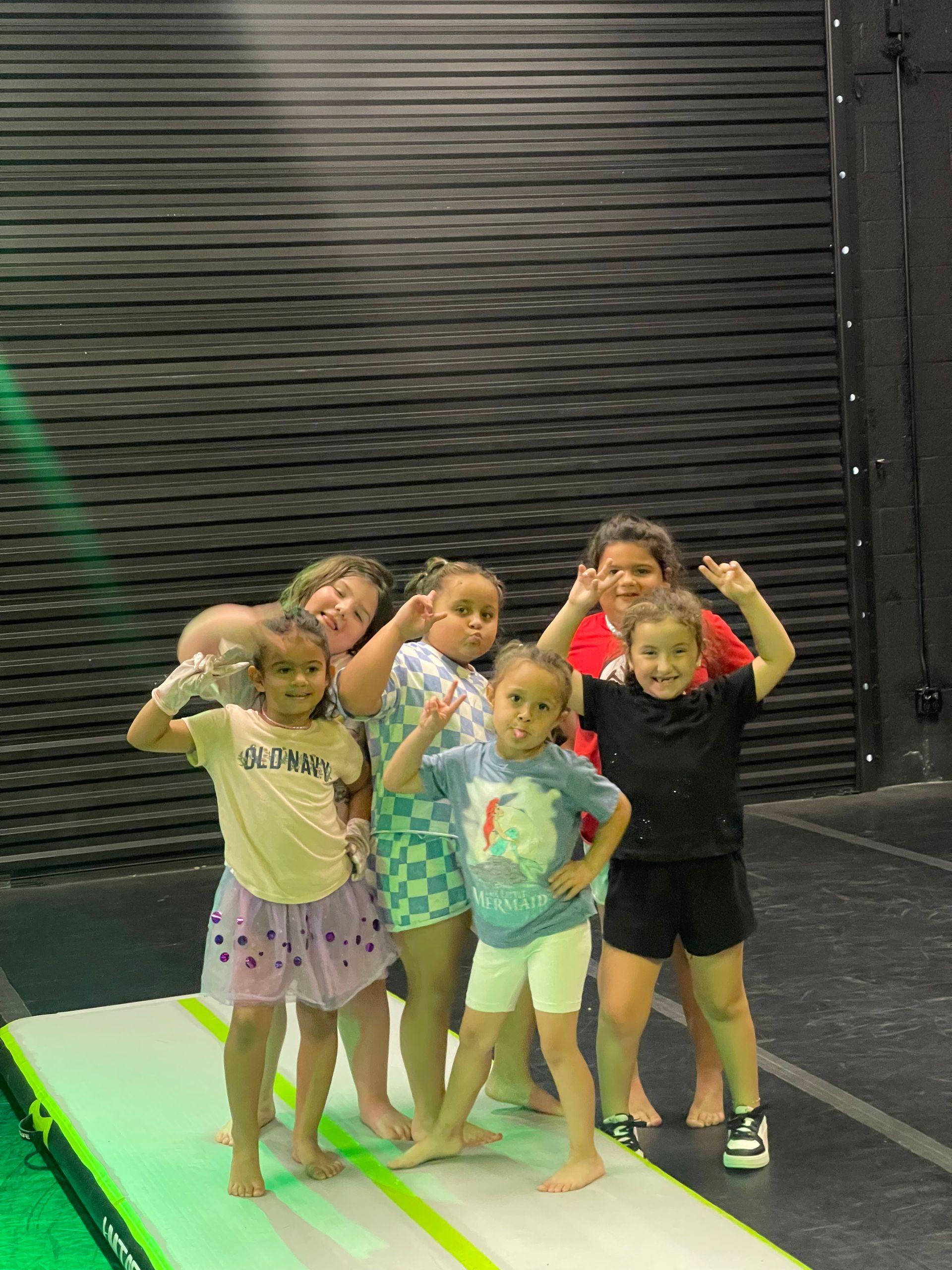 A group of young girls are posing for a picture on an air mat.